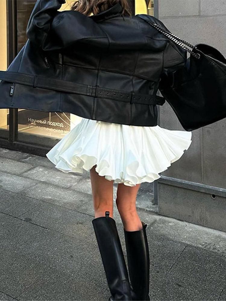 Woman wearing a Vintage Pleated Ruffled Mini Skirt, paired with black boots and leather jacket, perfect for country festivals and rodeos.