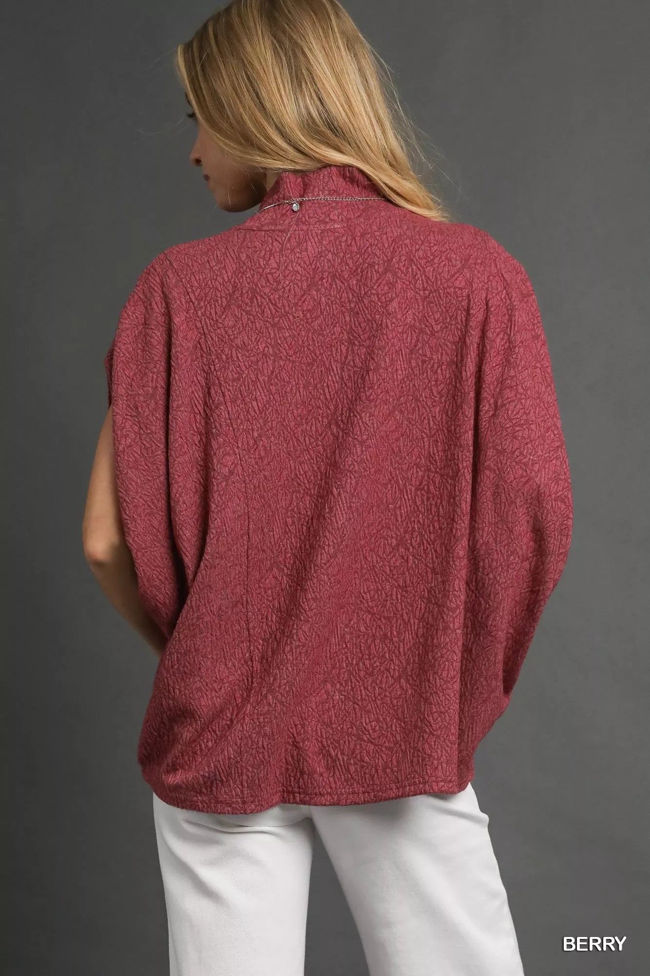 Back view of Umgee Textured Mock Neck Relaxed Top in berry color with dolman sleeves and mock neck design.