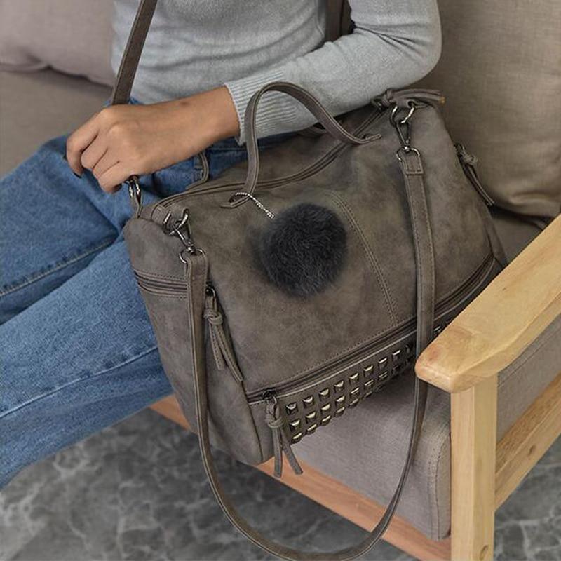 Woman holding Rustic Charm Leather Shoulder Bag – Stylish Cowgirl Handbag with rivet details and soft, spacious design.