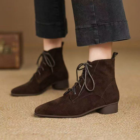 Woman wearing Maillard Matte Pointed Low-Heel Ankle Boots with black pants on carpeted floor.
