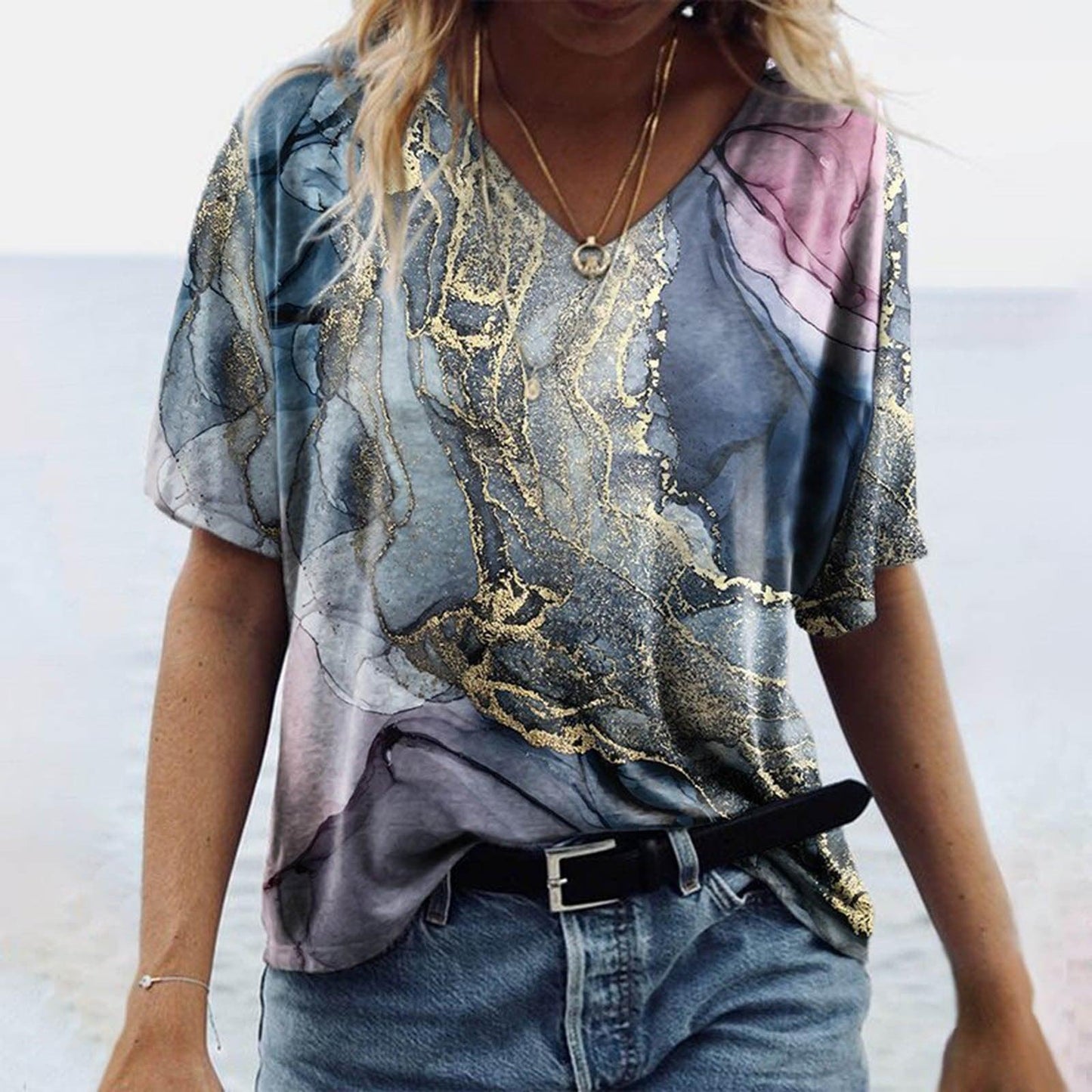 Model wearing Women's Spring Glitzy V-Neck Short Sleeved Marble Print Top with tie-dye effect and glitzy V-neckline.