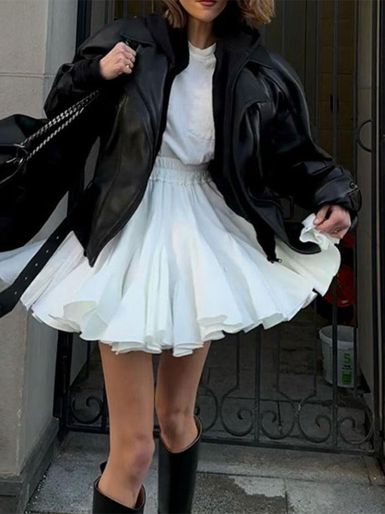 Woman wearing Vintage Pleated Ruffled Mini Skirt | Country Girl Festival & Rodeo Skirt, styled with black leather jacket.