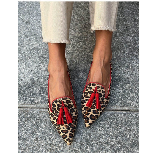 Cow Print Tassel Pumps Women | Casual Slip-On Style with leopard pattern and red tassels shown on feet, perfect for casual outings.