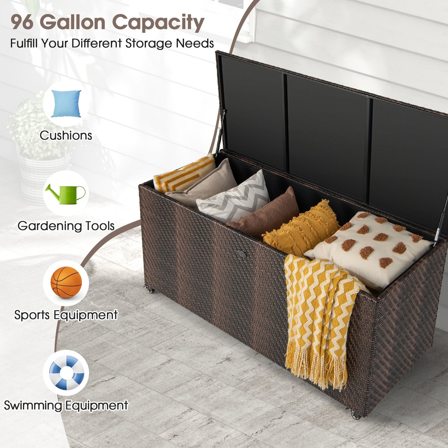 96 Gallon PE Wicker Outdoor Storage Box with 4 Wheels-Brown, open showing stored cushions, sports gear, and gardening tools.