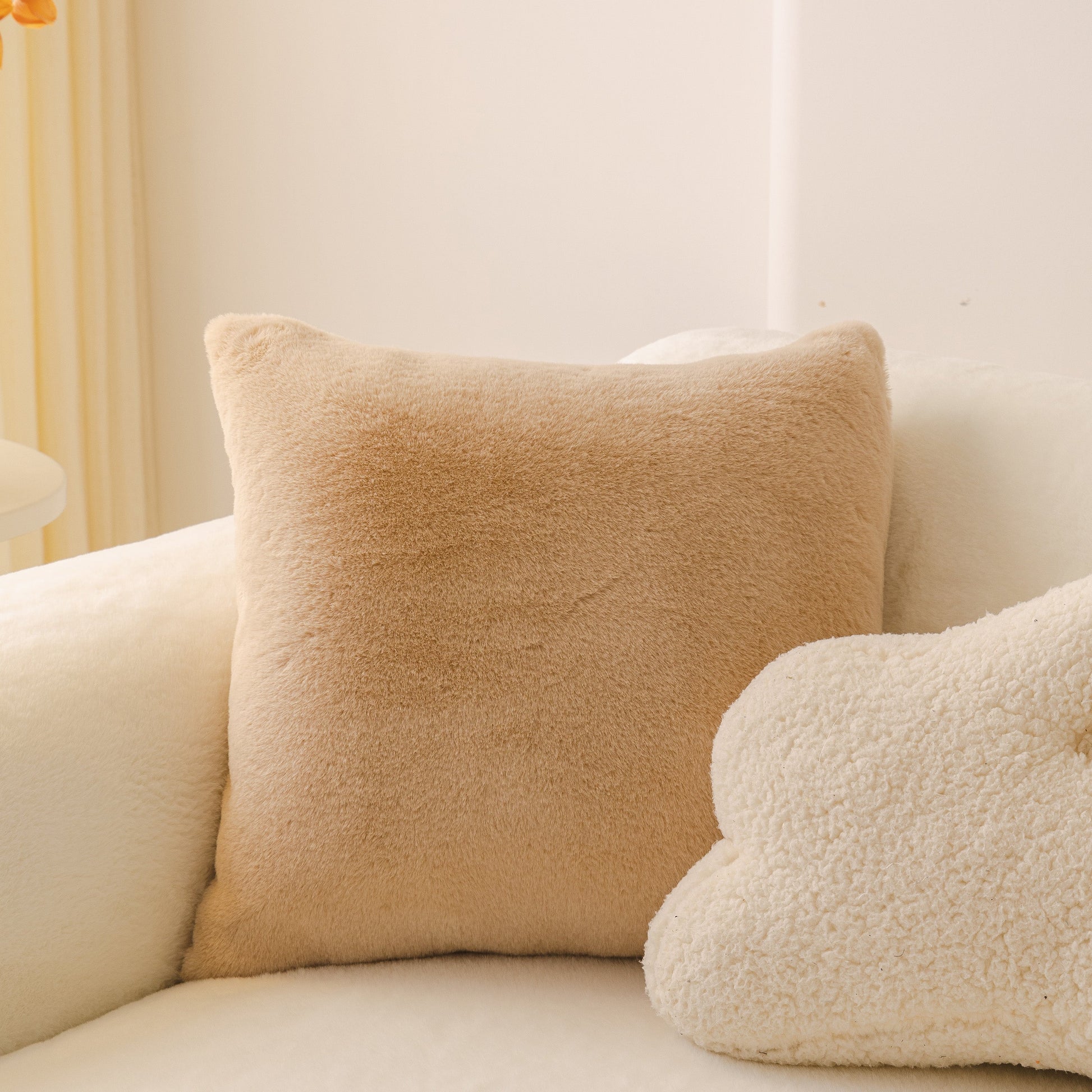 Beige plush pillows on a cozy sofa, showcasing the Soft Plush Warm Sofa Cover Stretchable Cozy Velvet Couch Protector for Fall & Winter.