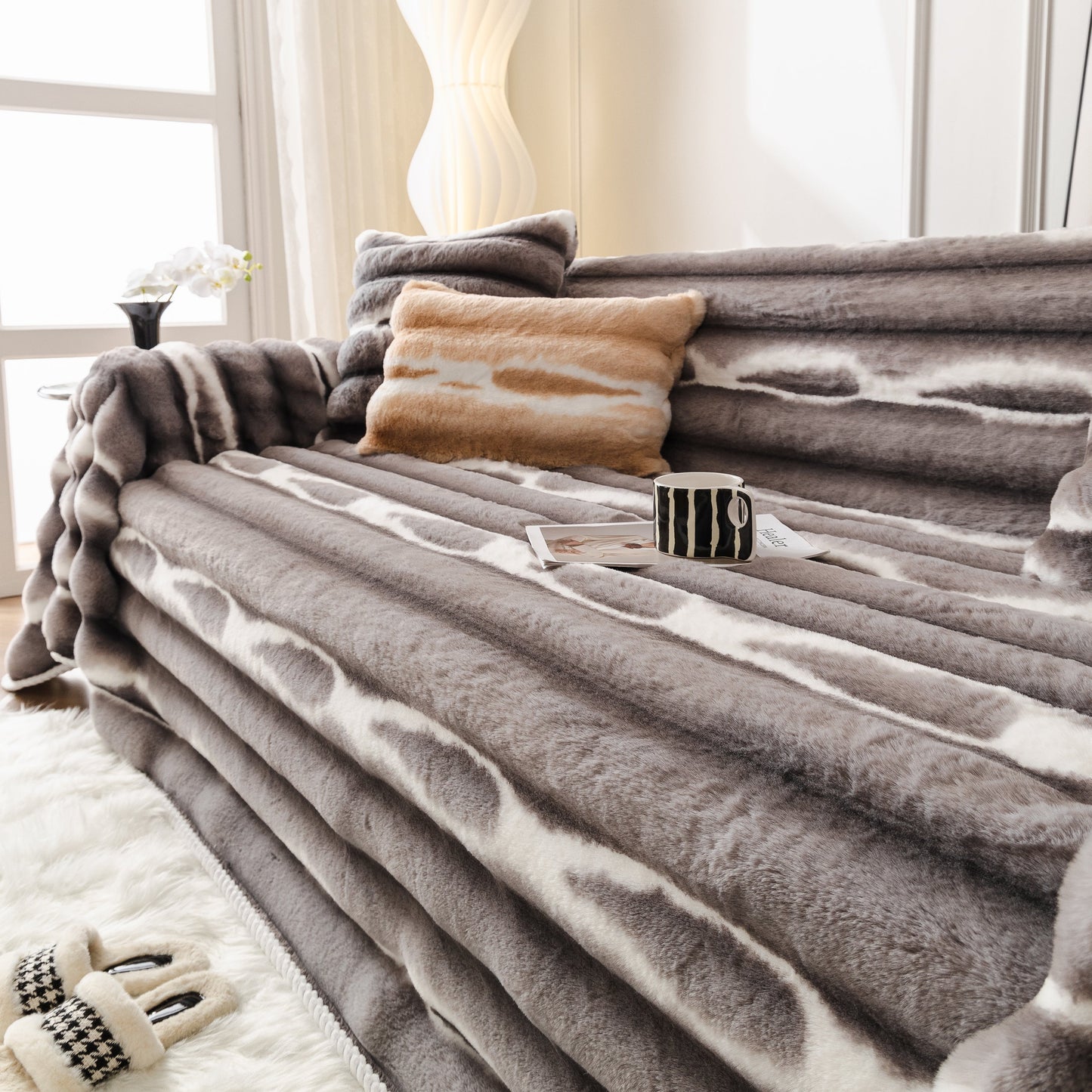 Ultra Soft Faux Fur Couch Cover – Large, Fluffy, and Elegant Sofa Throw Blanket on a modern sofa with cushions and a mug.