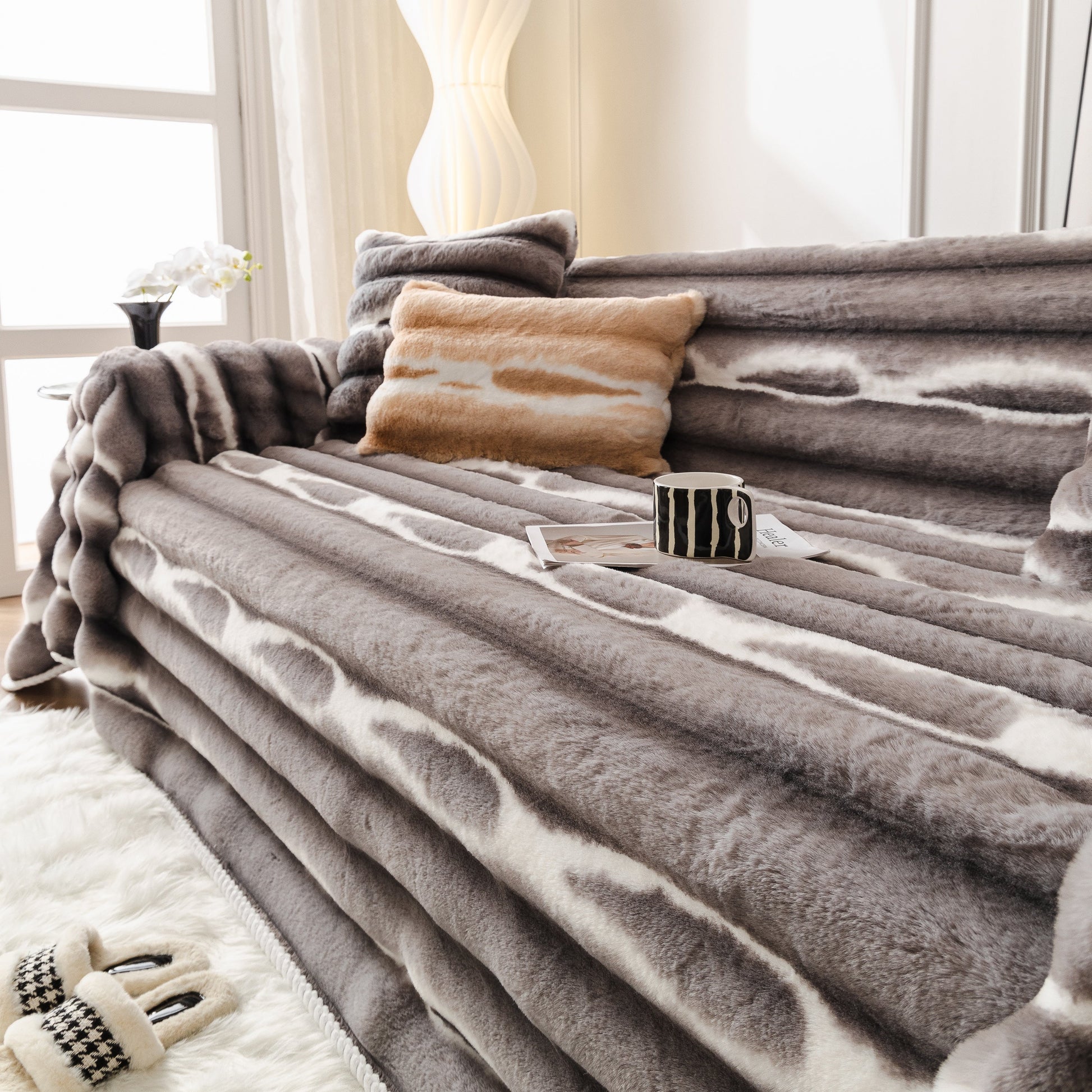 Ultra Soft Faux Fur Couch Cover – Large, Fluffy, and Elegant Sofa Throw Blanket on a modern sofa with cushions and a mug.