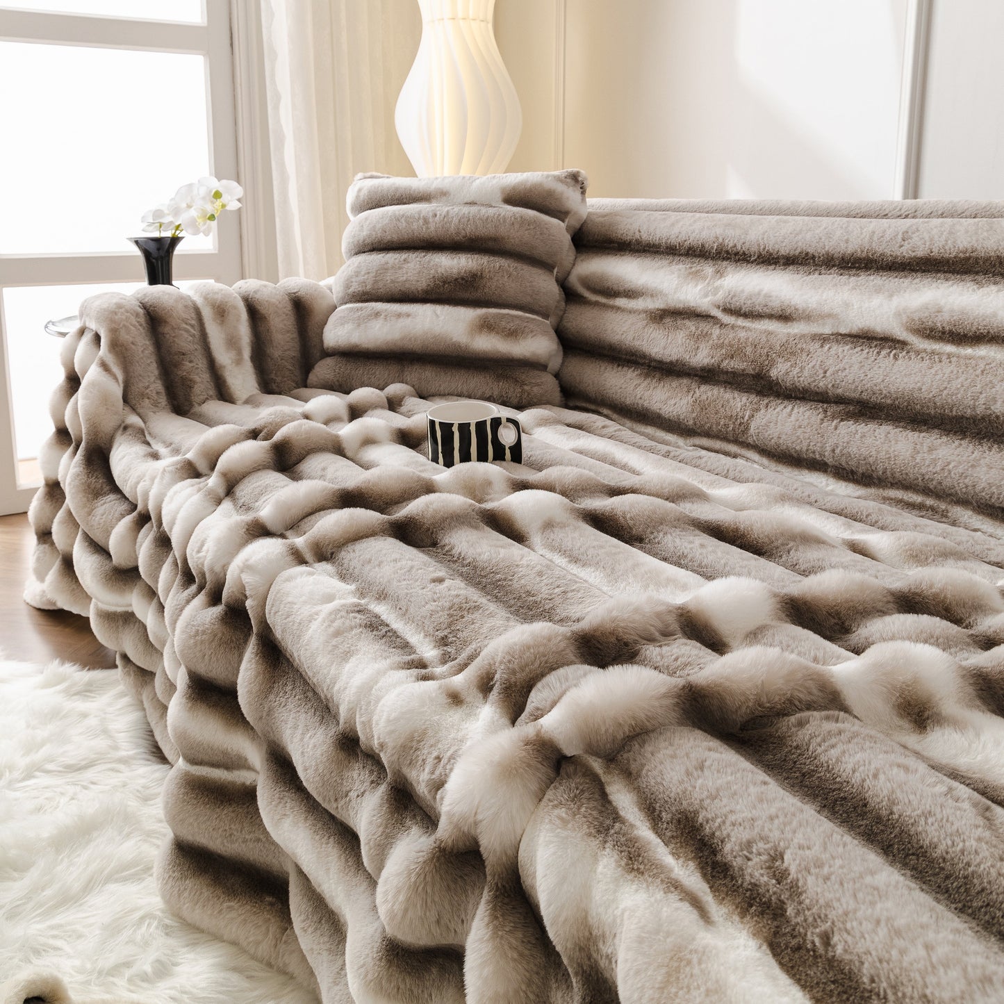 Ultra Soft Faux Fur Couch Cover – Large, Fluffy, and Elegant Sofa Throw Blanket elegantly draped over a modern sofa in a bright room.