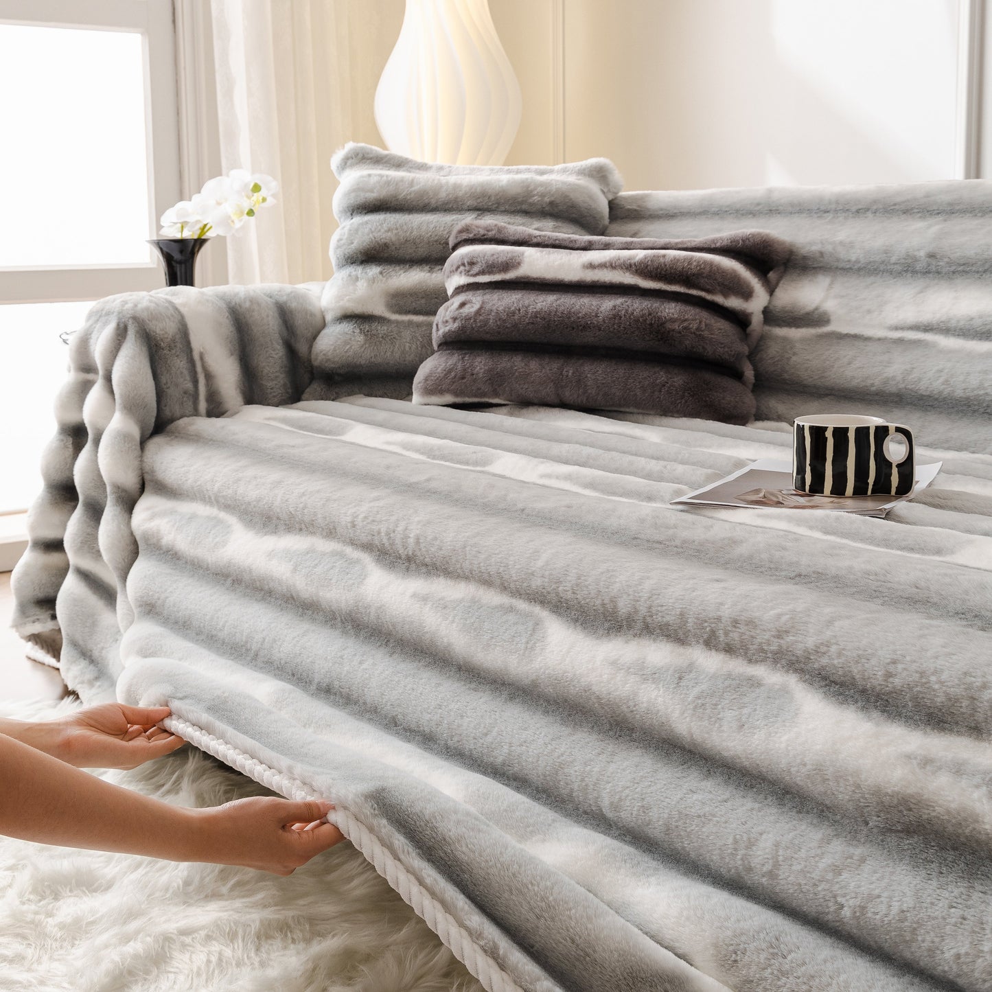 Ultra Soft Faux Fur Couch Cover – Large, Fluffy, and Elegant Sofa Throw Blanket on a modern sofa with a cup and stacked pillows.