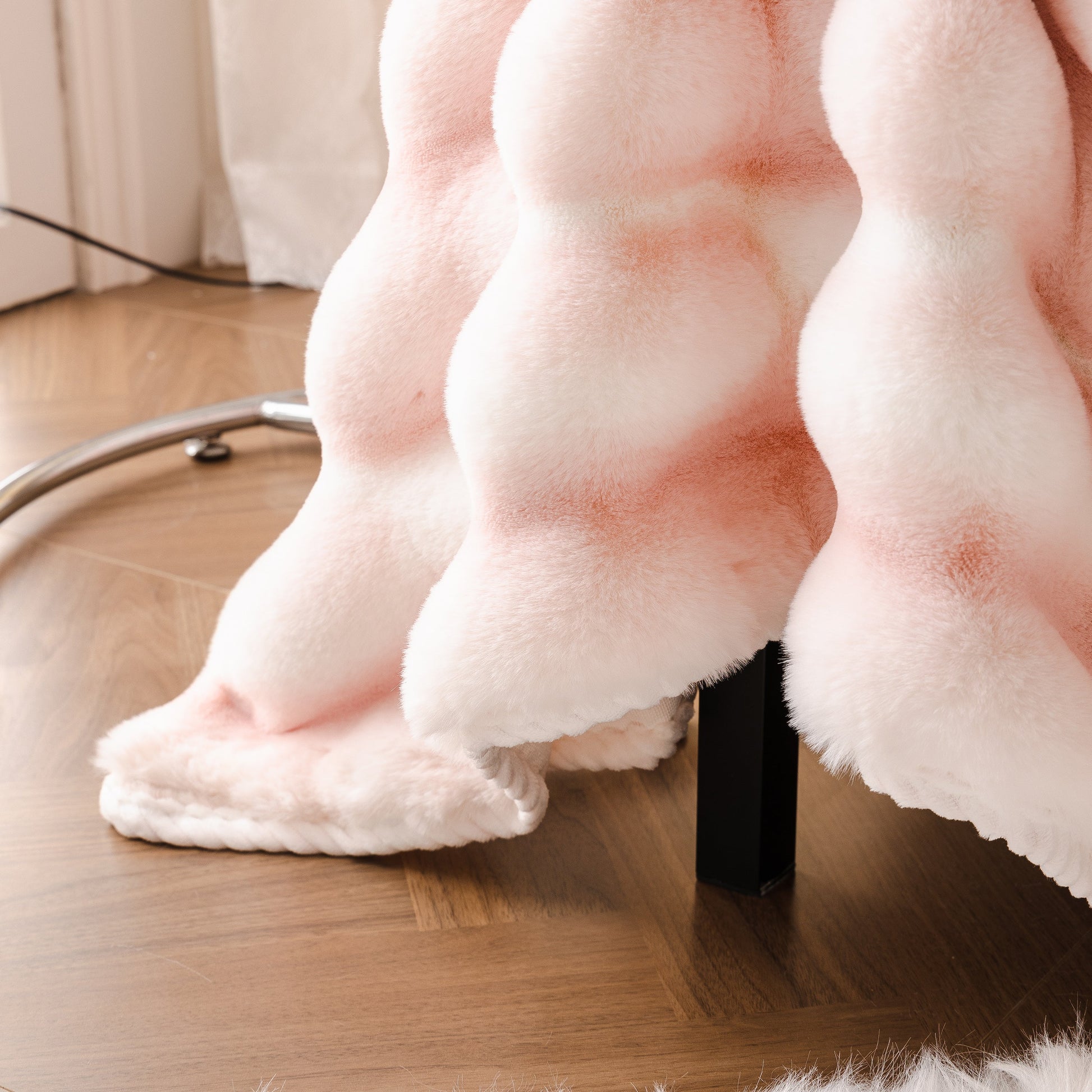 Close-up of gradient Ultra Soft Faux Fur Couch Cover – Large, Fluffy, and Elegant Sofa Throw Blanket draped over a chair leg on wooden floor.