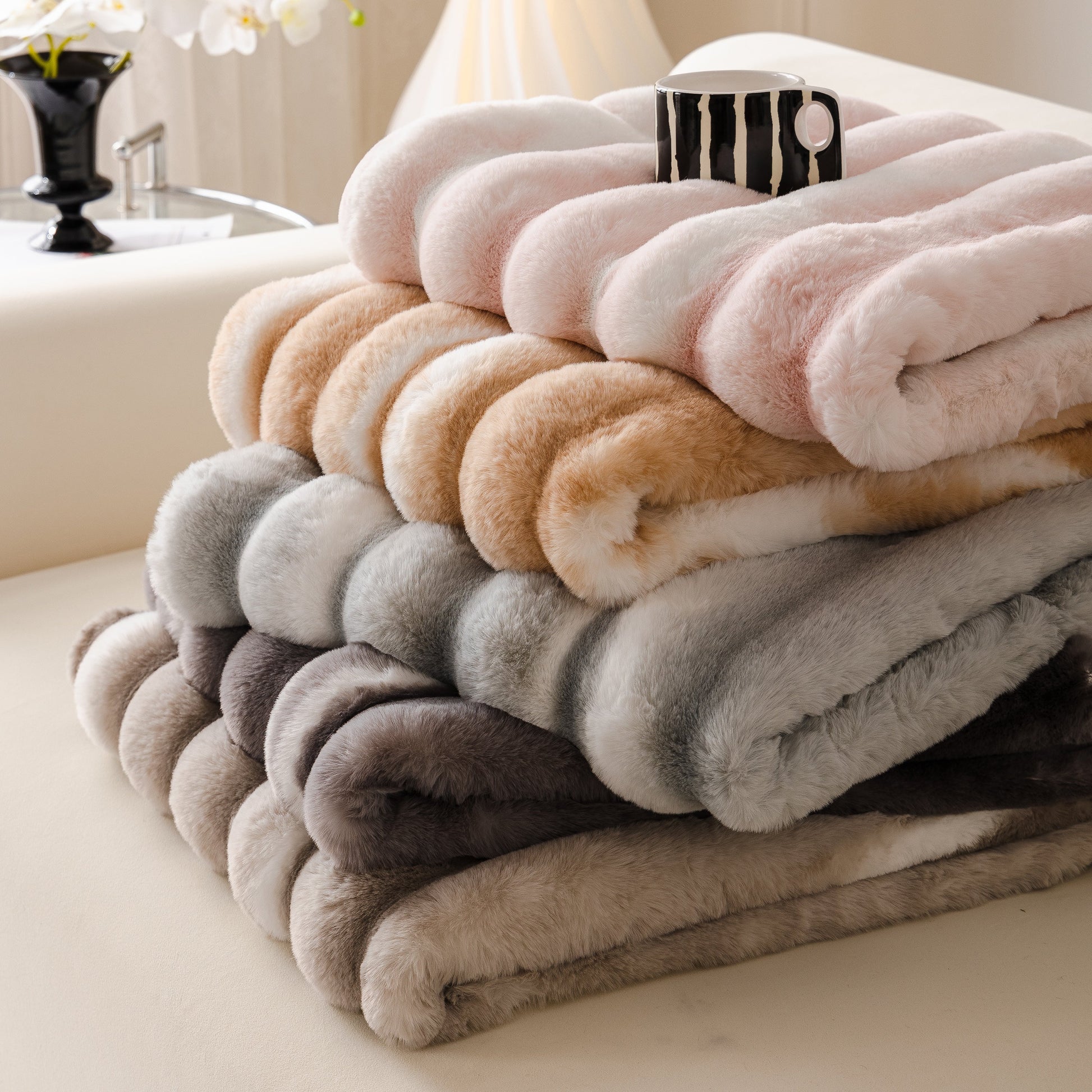 Ultra Soft Faux Fur Couch Cover – Large, Fluffy, and Elegant Sofa Throw Blanket in various colors stacked on a couch.