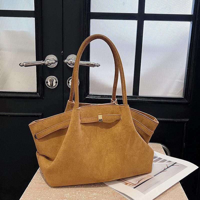 Cowgirl Suede Tote Bag – Stylish and Practical Western Handbag on a table with a rustic door background