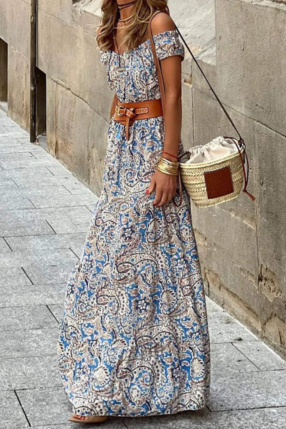 Woman wearing Prairie Blossom Off-Shoulder Maxi Dress with floral print, standing in an outdoor urban setting