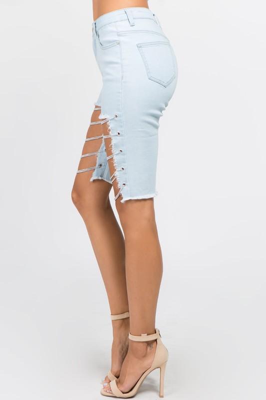 Woman wearing cutoff Bermuda shorts with chains, stonewashed denim, country girl style for summer and spring fashion.