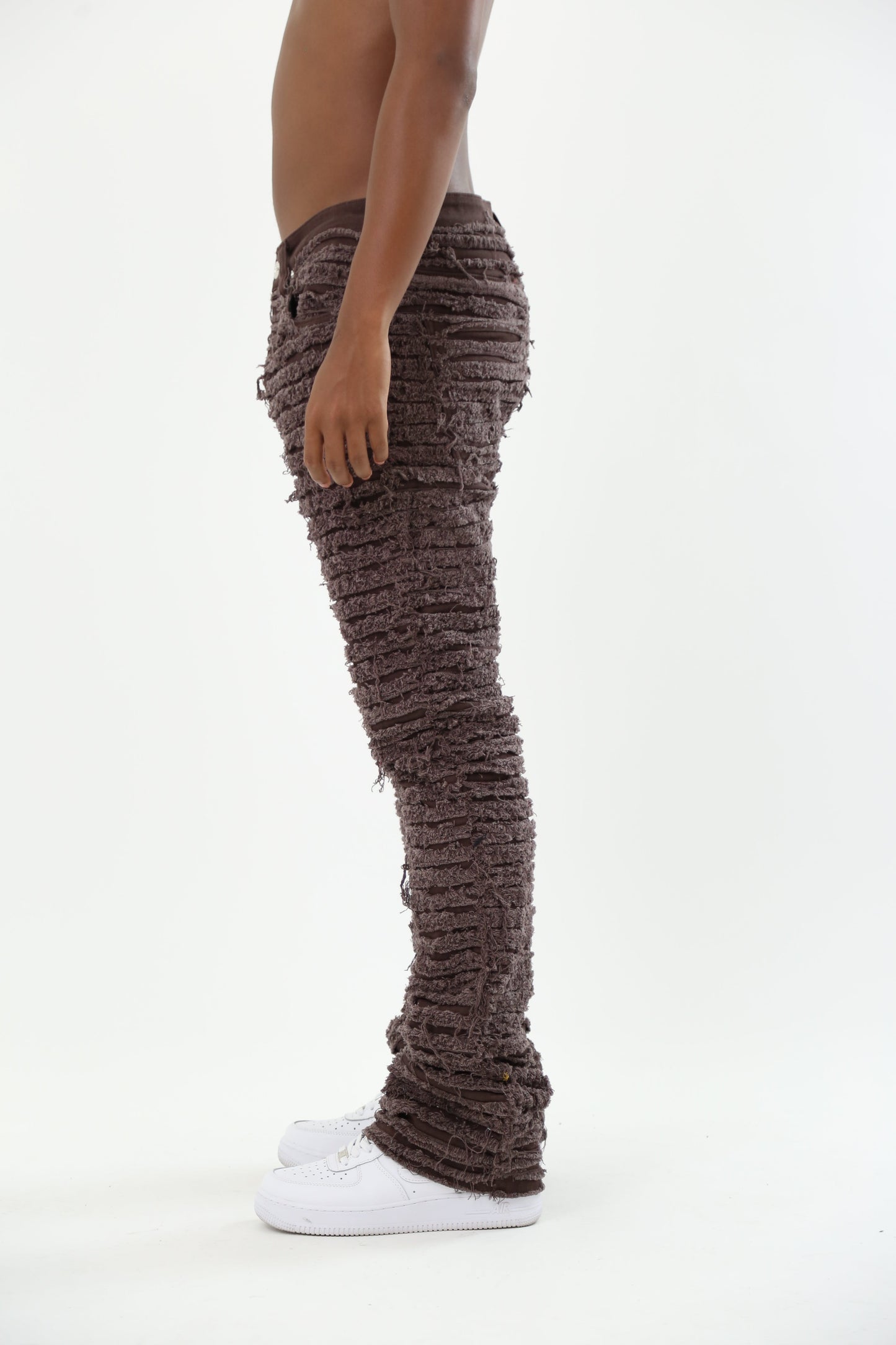 Side view of AJS693 EXTREME FRAYED STACKED JEANS on model, mid rise, stretchy cotton, featuring frayed inseam and stacked leg design.