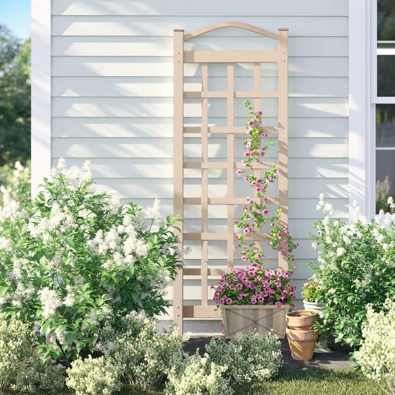 76-inch Tall Mocha Tan Brown Vinyl Garden Trellis with plants and flowers against a house wall