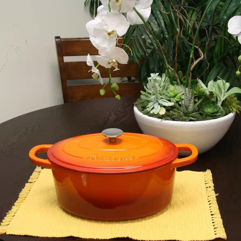 7-Quart Enameled Orange Sunburst Cast Iron Dutch Oven with Lid on table