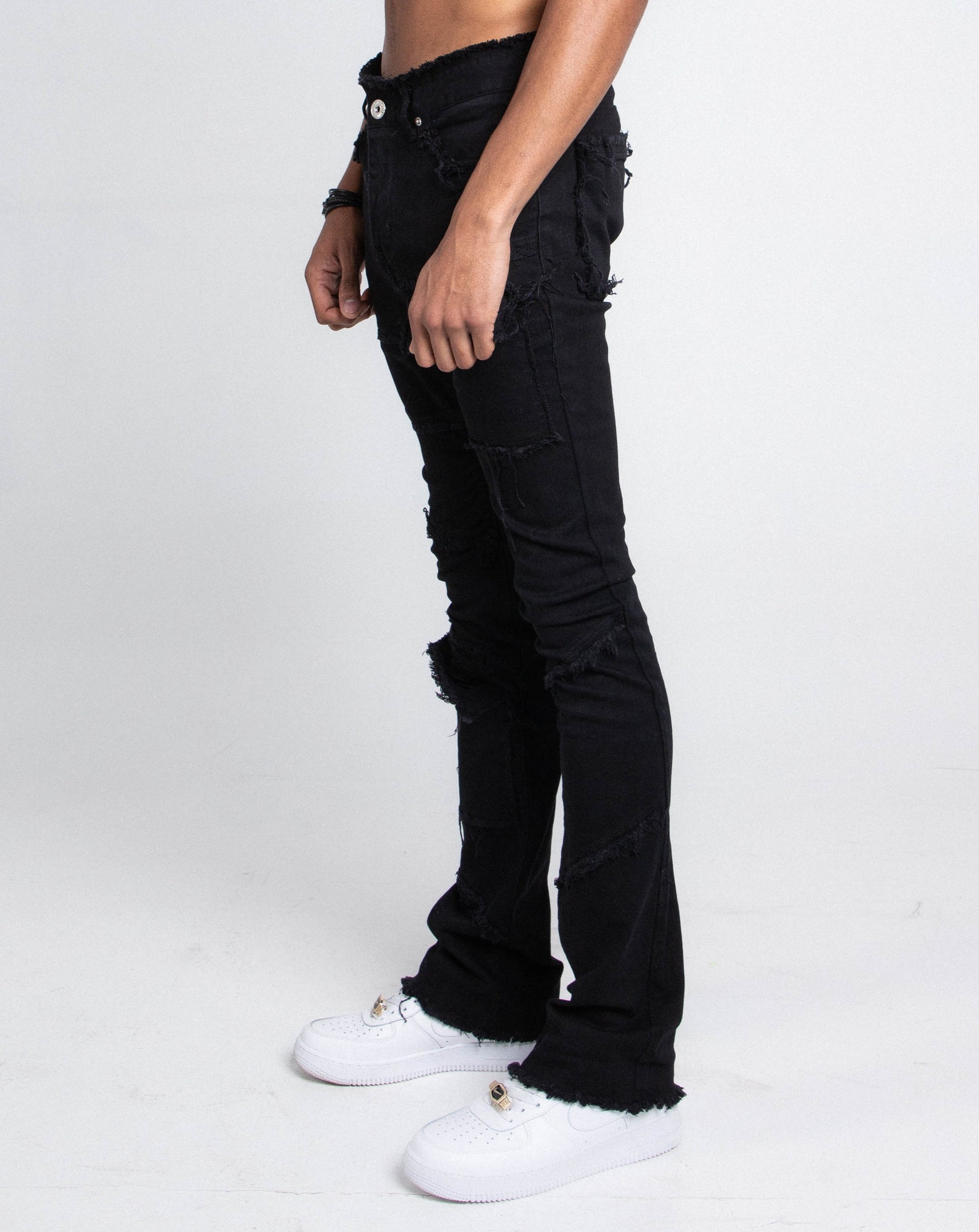 Model wearing AS405 BLACK DISTRESSED STACKED JEANS showing side view detail and fit.