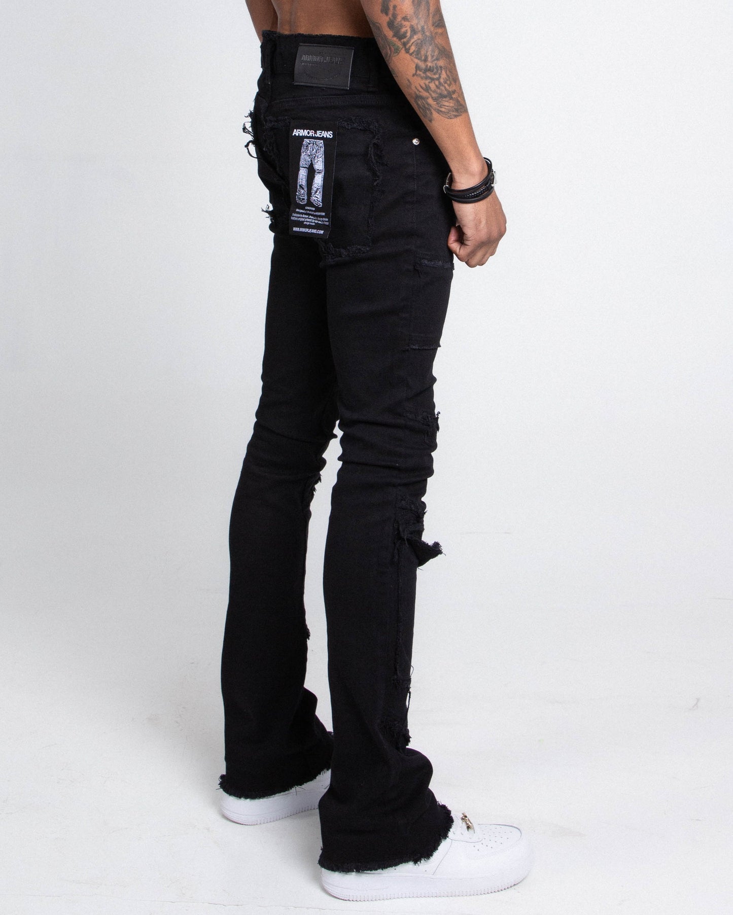 Model wearing AS405 BLACK DISTRESSED STACKED JEANS with purple lace screen print, grey wash, and mid rise waist.