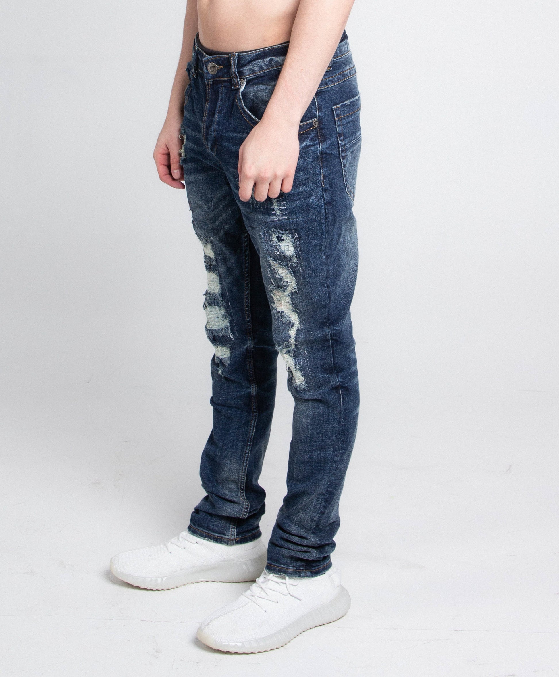 A403 SMALL RIPPED MID-RISE SKINNY JEANS with stretchy fabric, mid-rise waist, and distressed look, five pockets, worn with white sneakers.