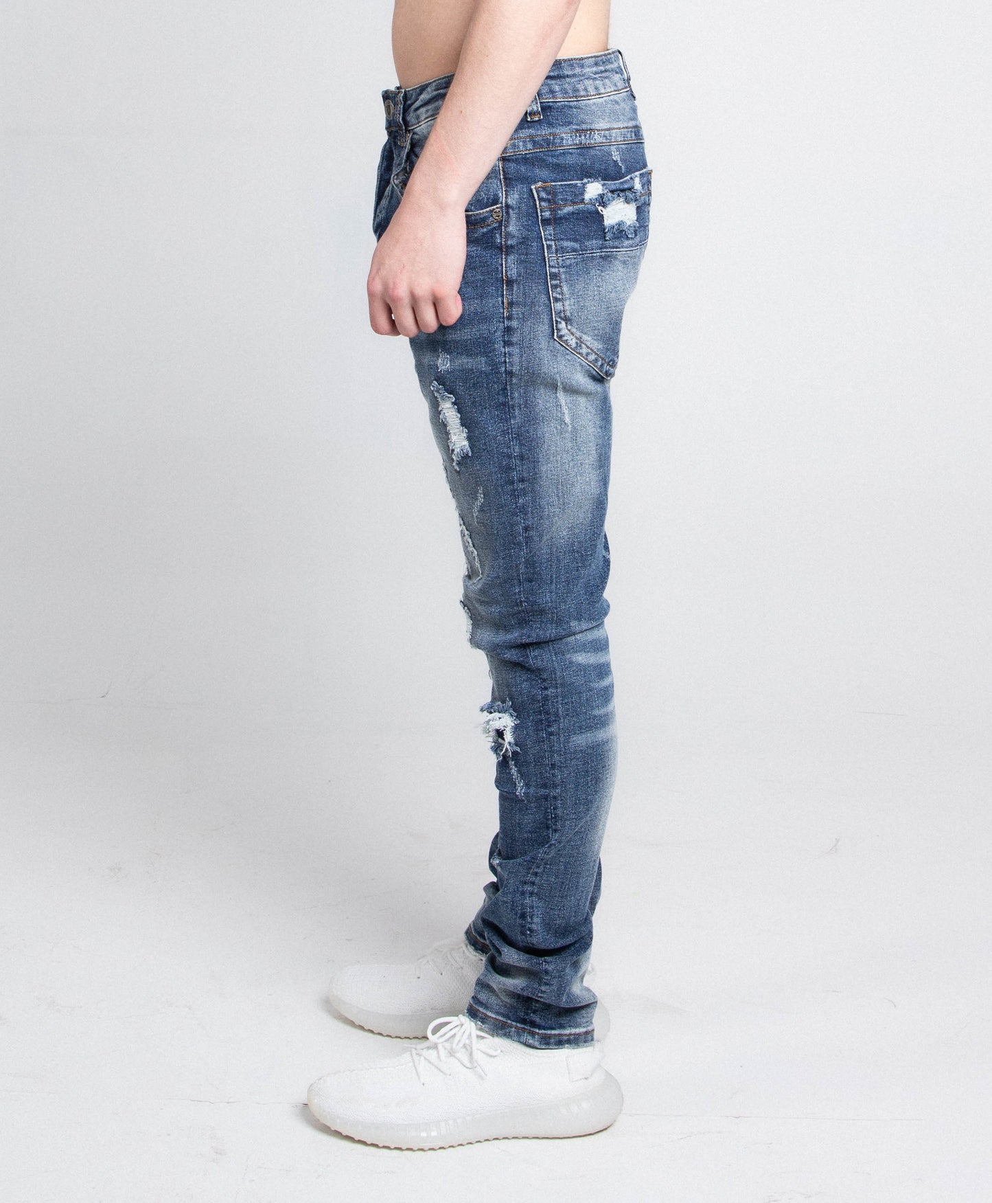 Side view of A406 CASUAL DISTRESSED SKINNY JEANS showcasing mid-rise waist and five-pocket design with stretchy fabric.
