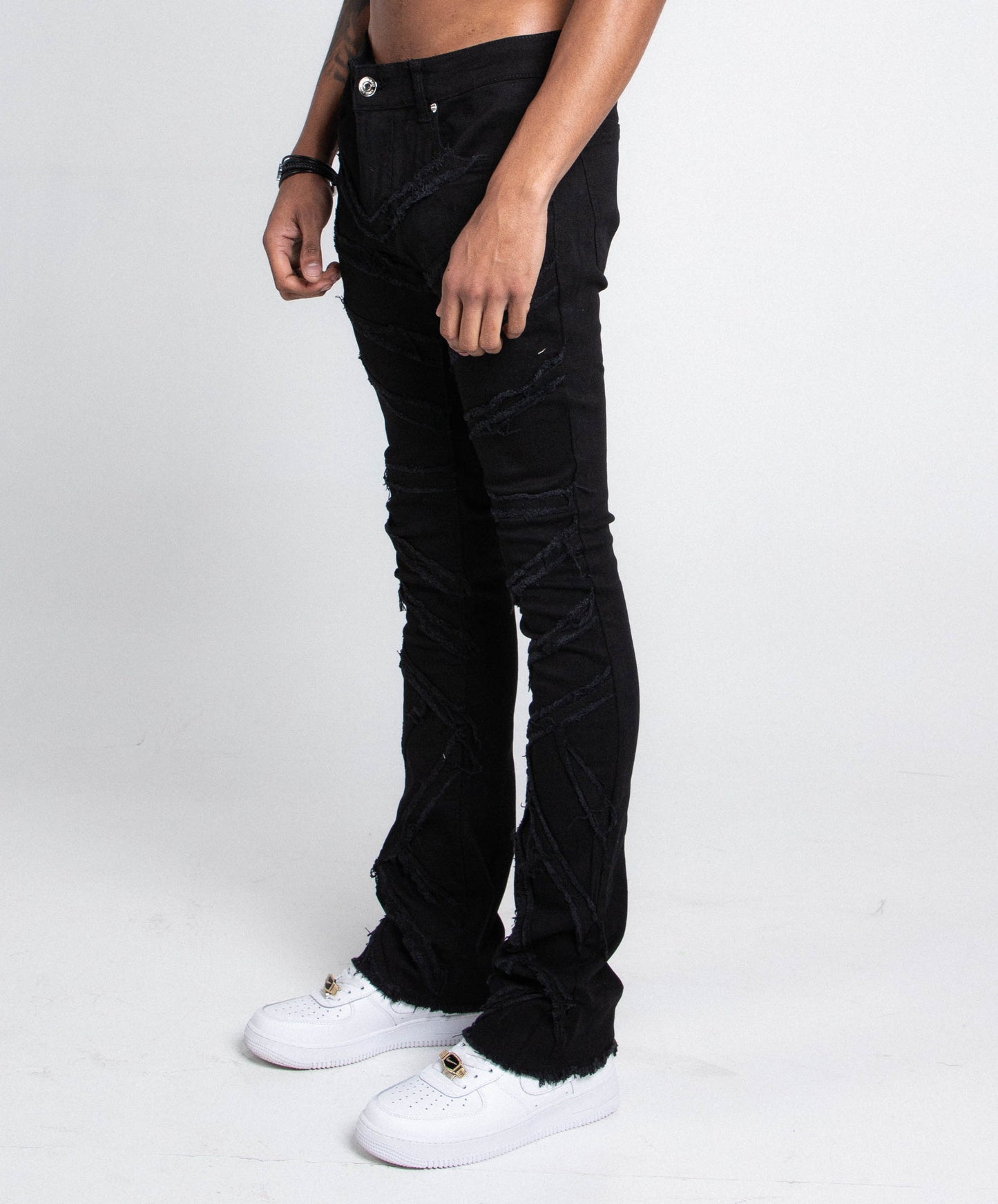 AJS410 SHREDDED STACKED JEANS mid-rise stretchy denim with shredded design, five pockets, and belt loops in black, side view.