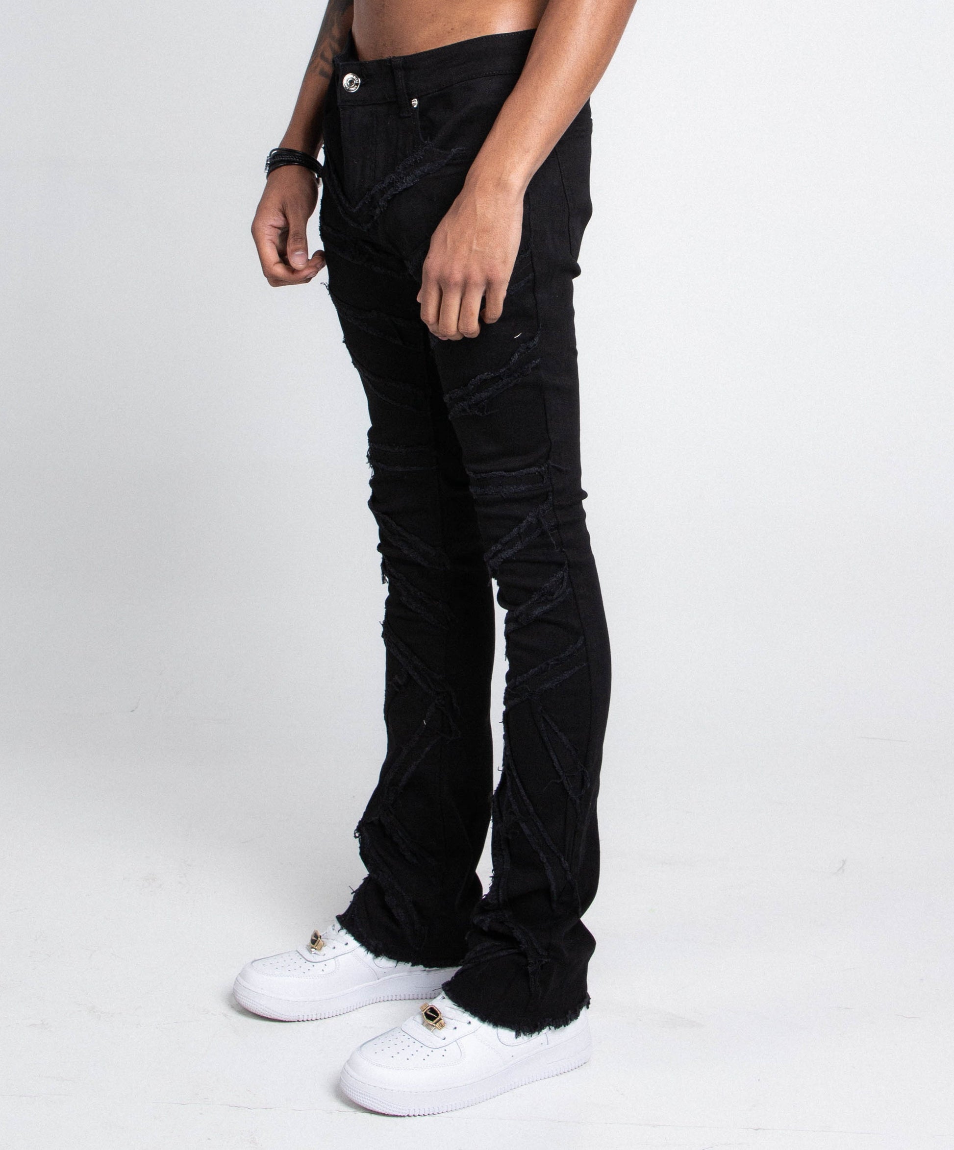 AJS410 SHREDDED STACKED JEANS mid-rise stretchy denim with shredded design, five pockets, and belt loops in black, side view.