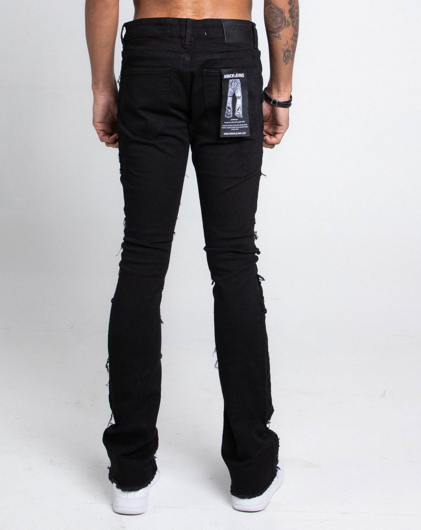 Back view of AS405 BLACK DISTRESSED STACKED JEANS with purple lace screen print and five-pocket design, mid-rise stretch cotton.