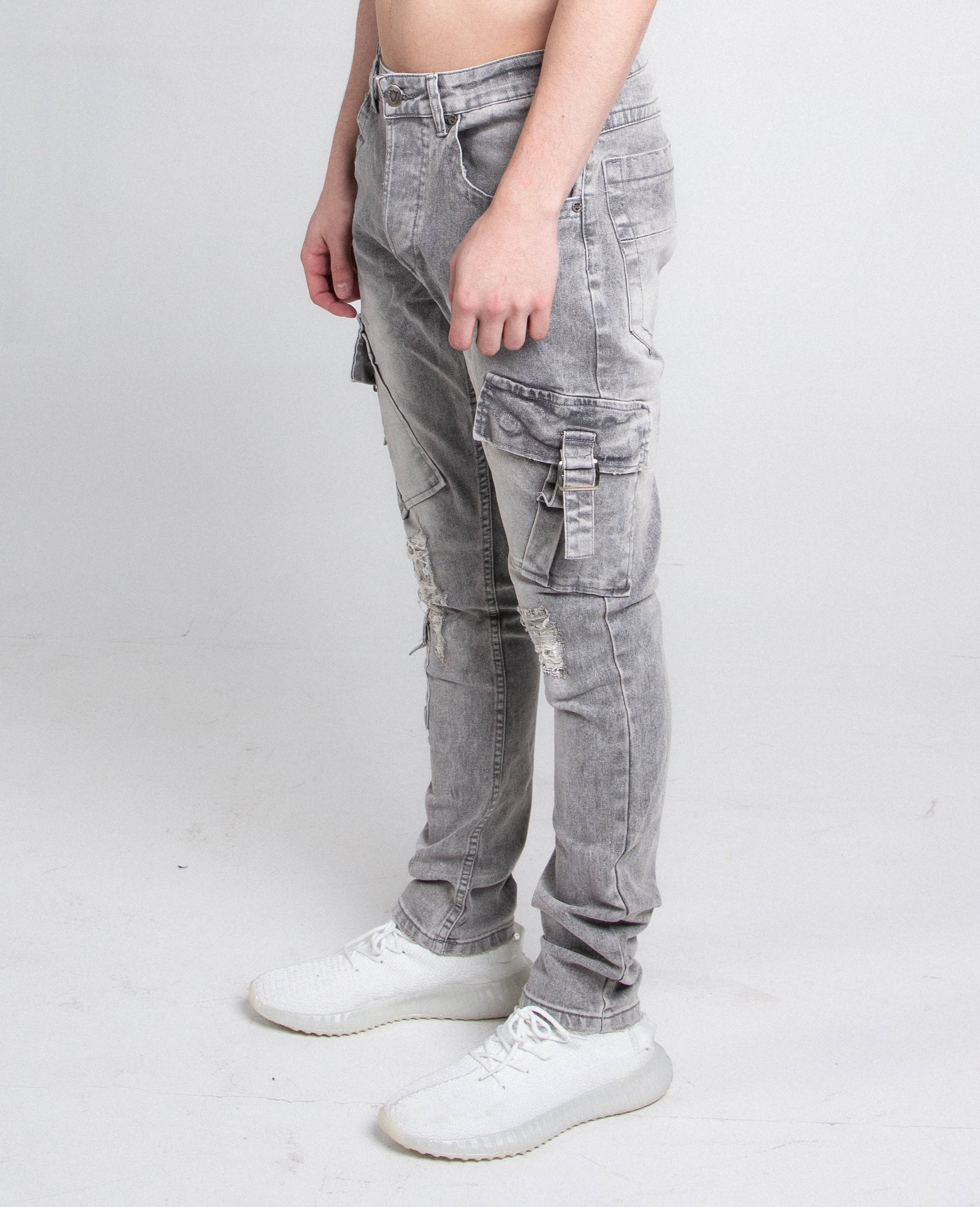 Model wearing A408 CARGO POCKETS GREY SKINNY jeans with mid-rise waist and ripped slim leg design, featuring five pockets and zipper closure.