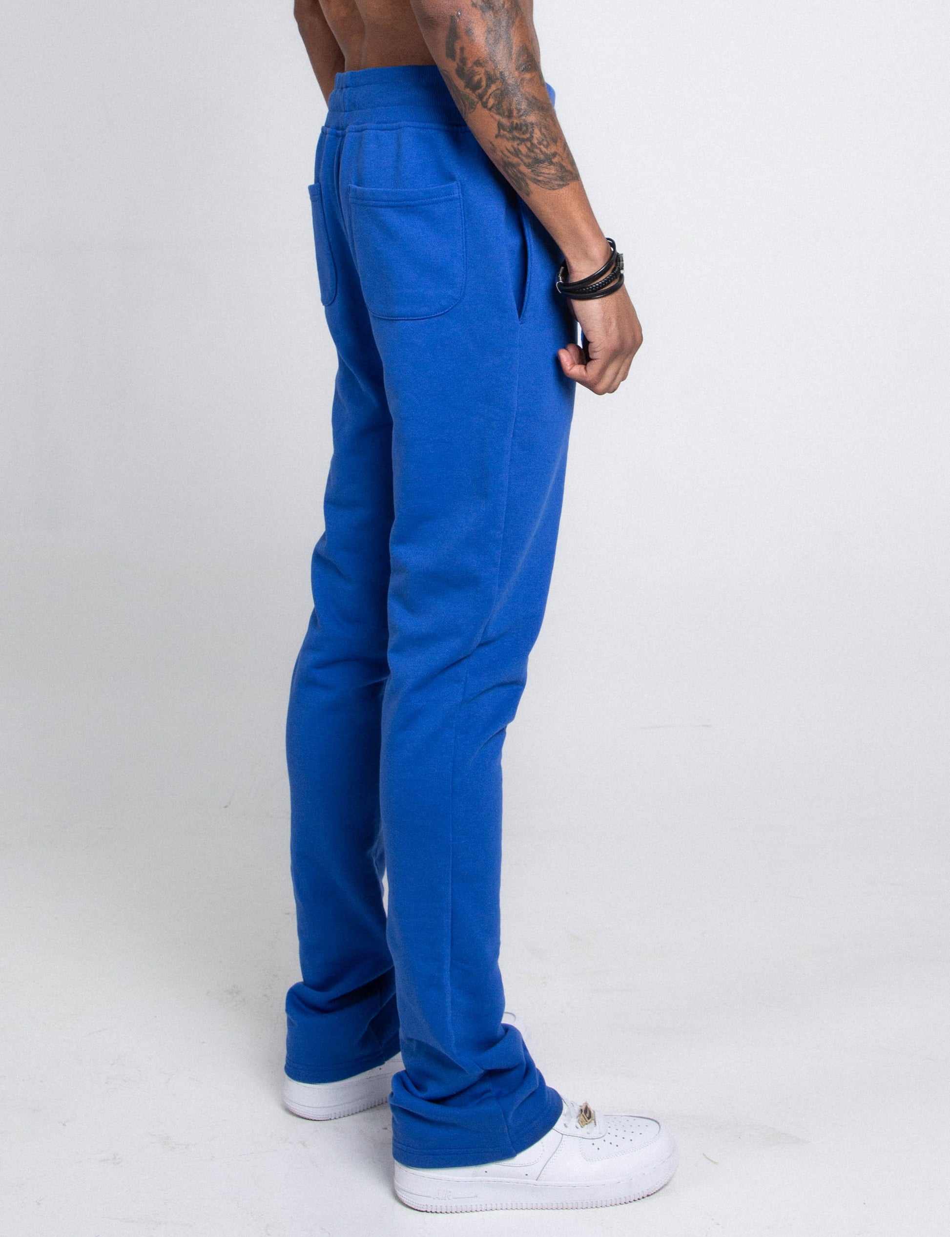 Side view of M5690-AJSKP MULTI-COLOR STACKED SWEATPANTS with elastic waistband and pockets shown in blue.