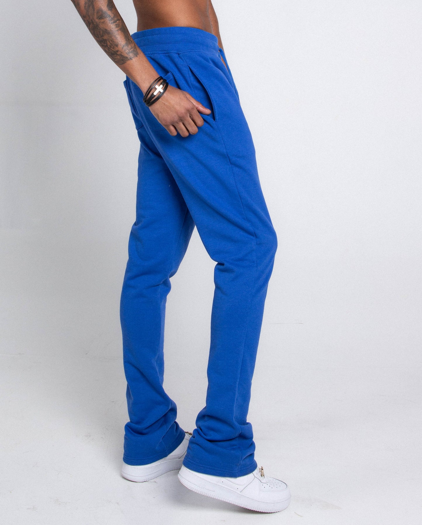Model wearing blue version of M5690-AJSKP MULTI-COLOR STACKED SWEATPANTS with elastic waistband and side pockets.