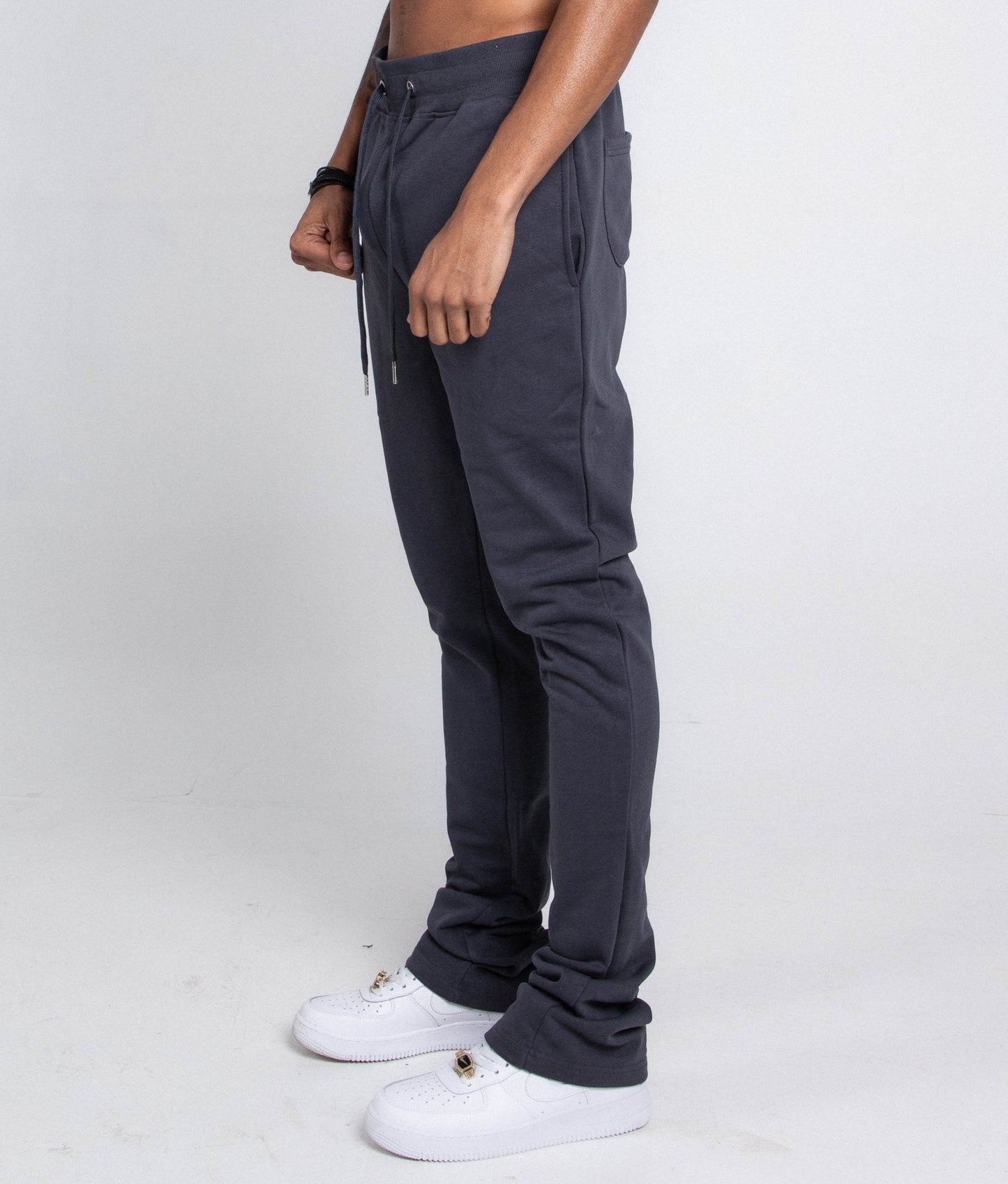 Side view of M5690-AJSKP MULTI-COLOR STACKED SWEATPANTS with elastic waistband and drawstrings, featuring back and side pockets.