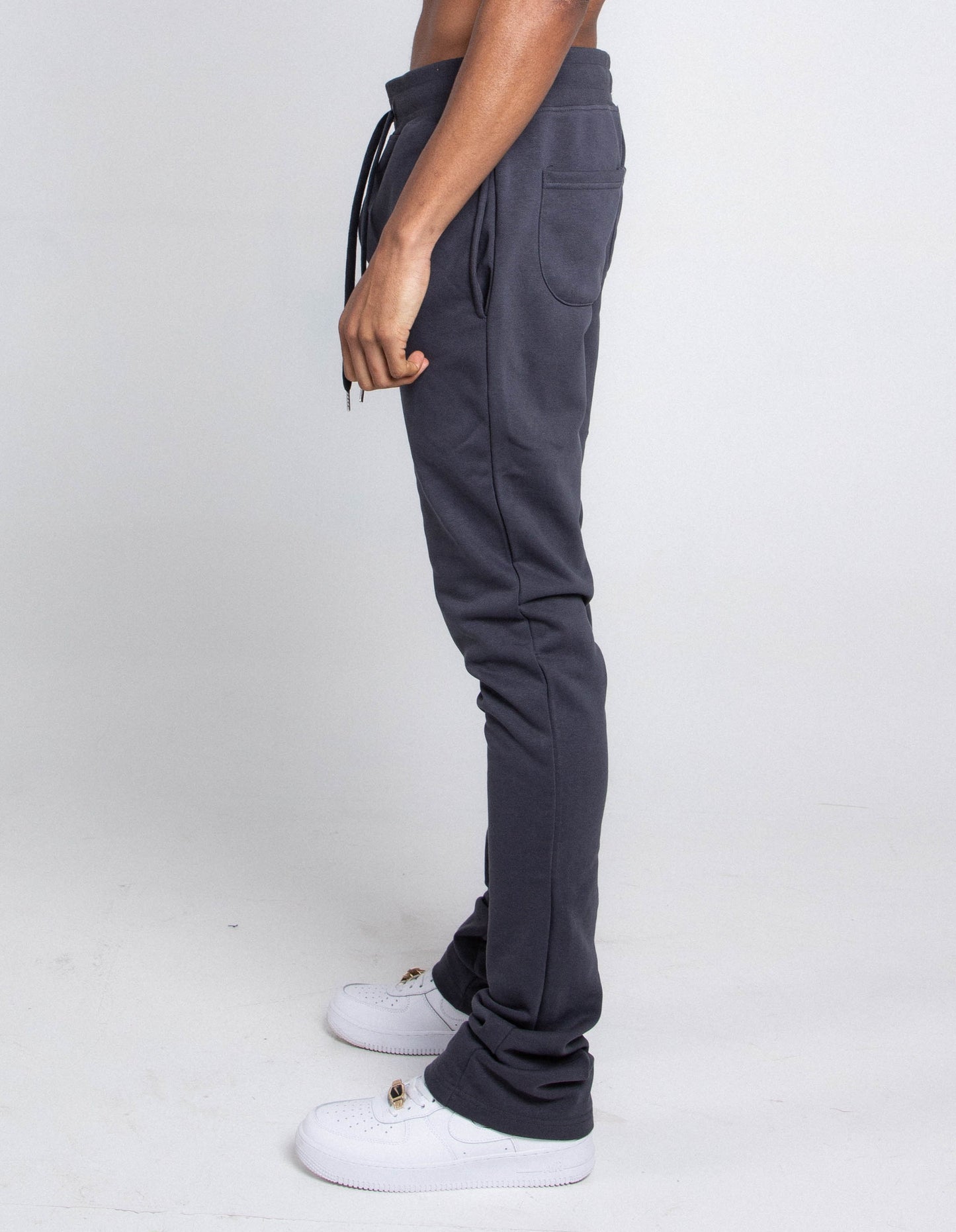 Side view of person wearing M5690-AJSKP MULTI-COLOR STACKED SWEATPANTS with elastic waistband and adjustable drawstrings.