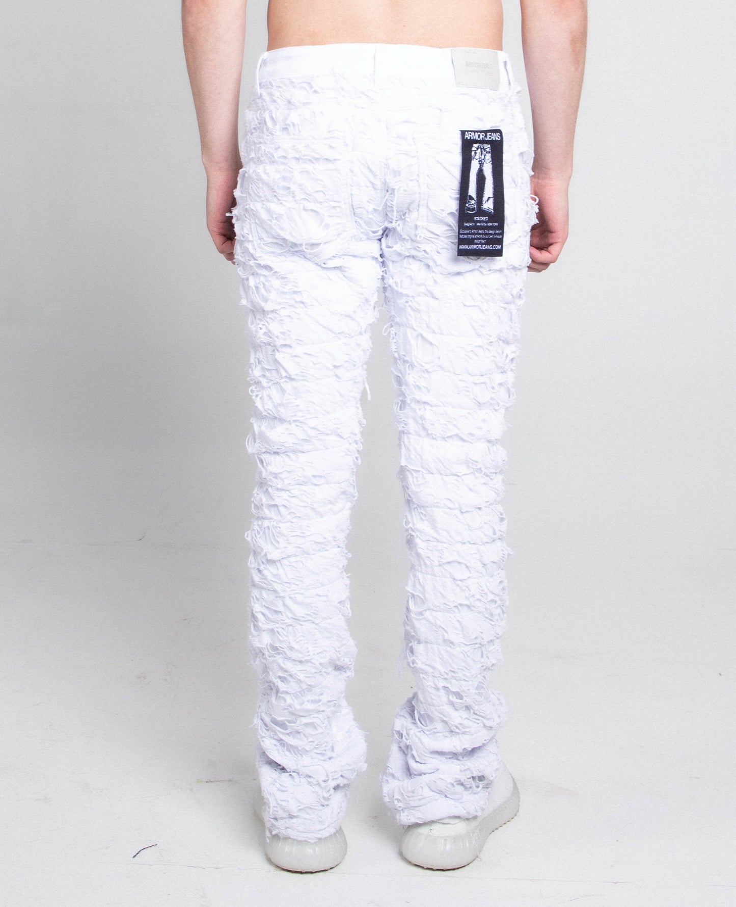 Back view of AR704 WHITE FRAYED STACKED JEANS with mid-rise waist, stretchy cotton fabric, and five-pocket design.