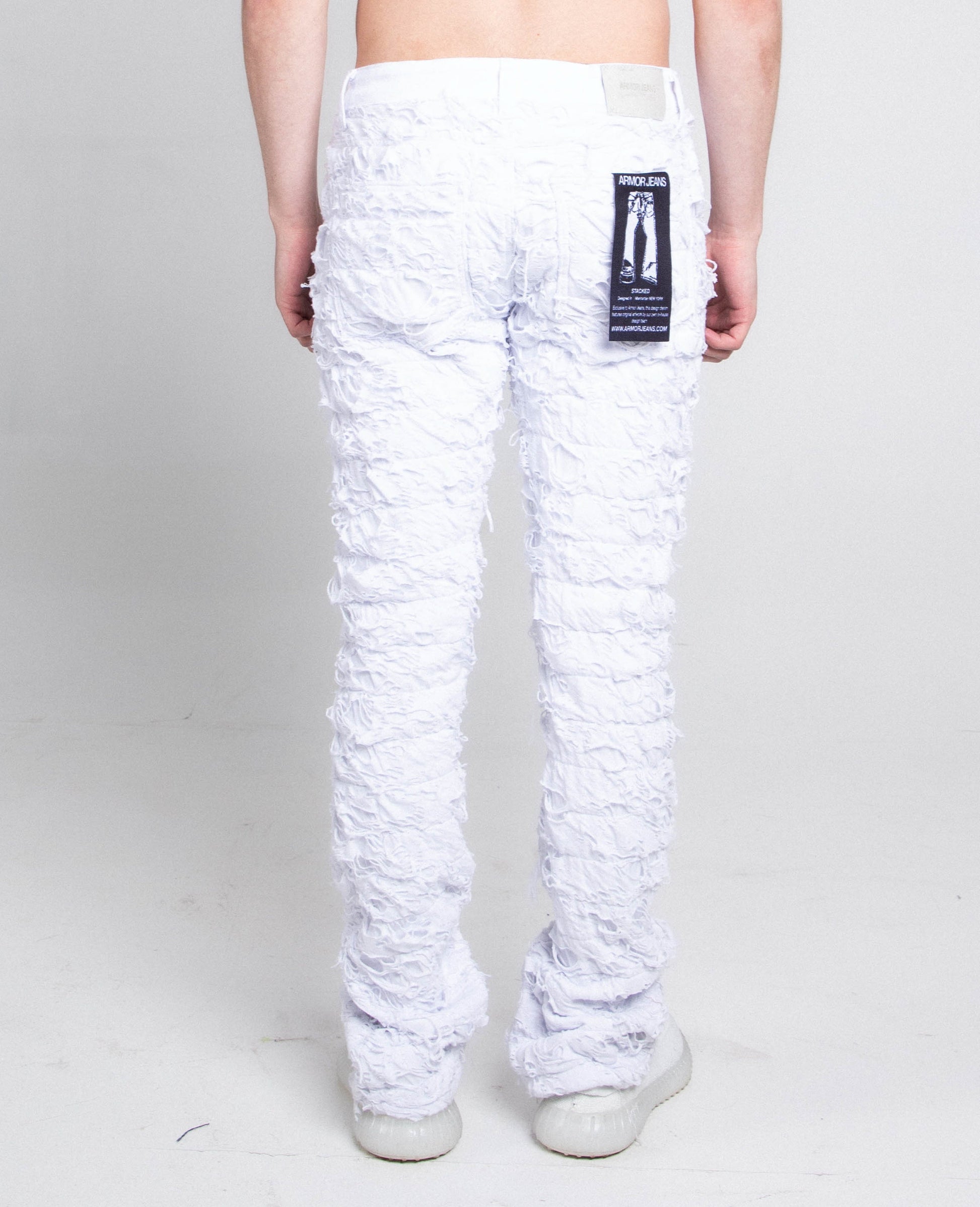 Back view of AR704 WHITE FRAYED STACKED JEANS with mid-rise waist, stretchy cotton fabric, and five-pocket design.