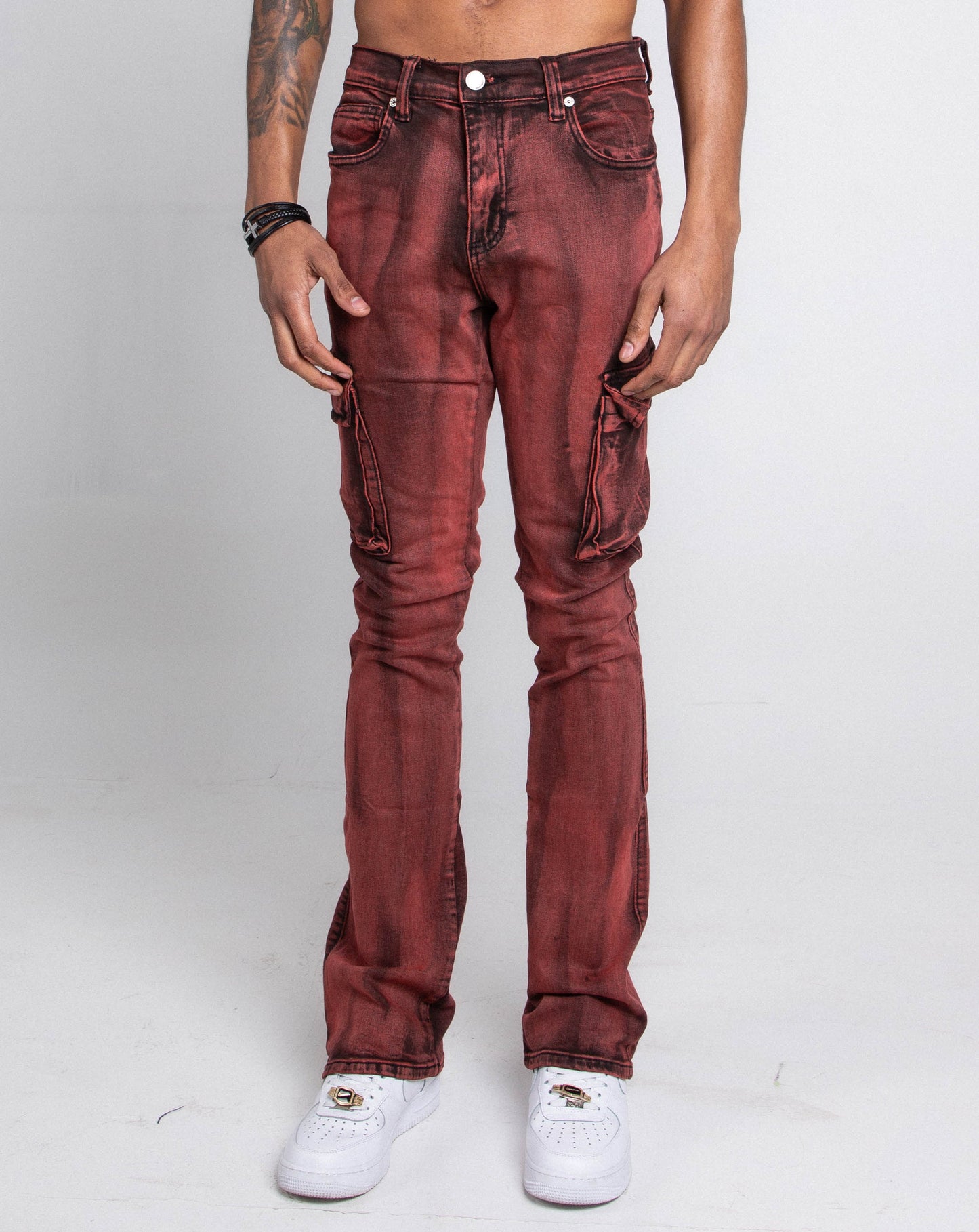 Man wearing AJ29SK GREY/WHITE WASH STACKED CARGO JEANS with splash paint effect, cargo pockets, and a mid-rise waist, styled with white sneakers.