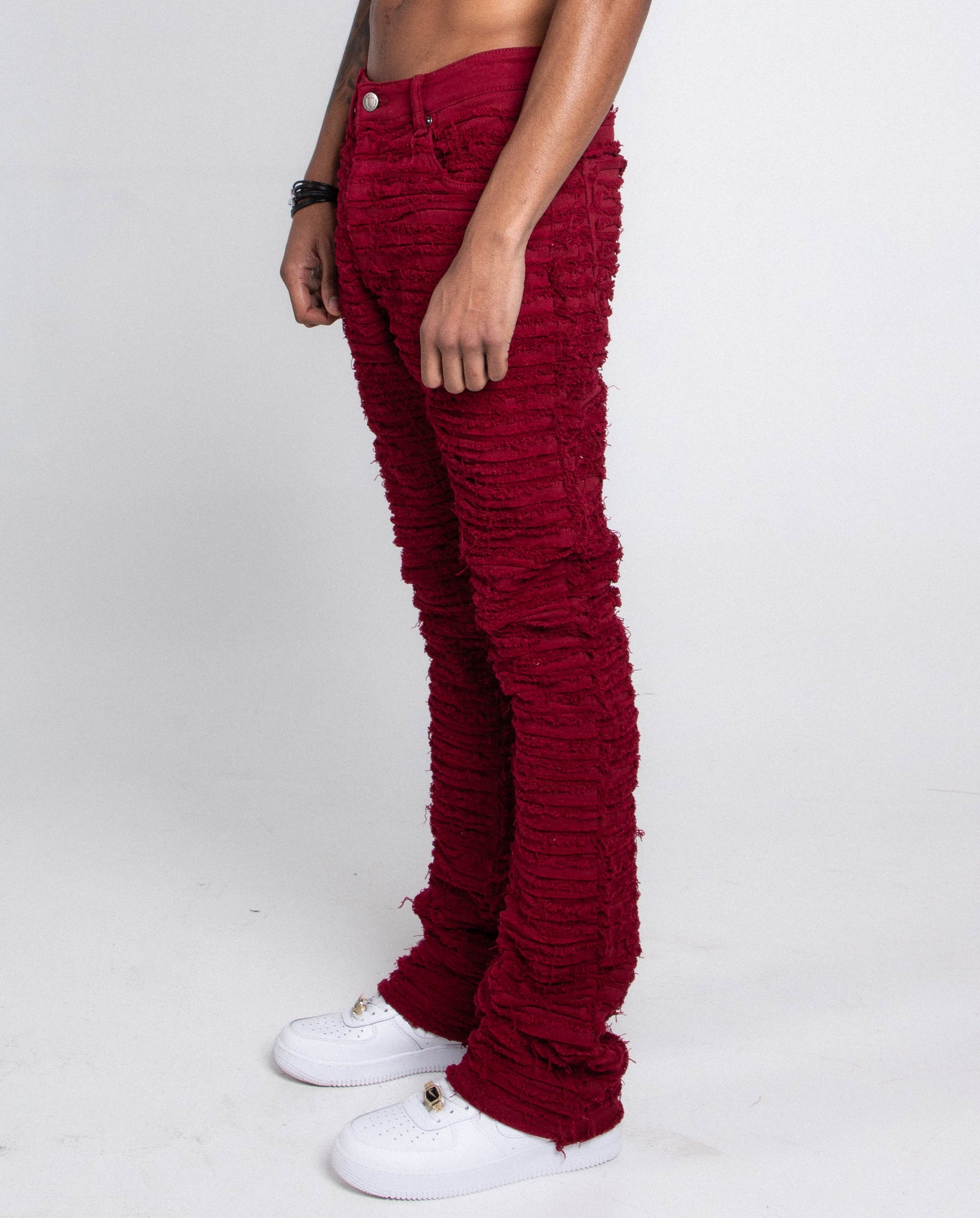 Model wearing AJS693 EXTREME FRAYED STACKED JEANS with mid-rise waist, stretchy cotton fabric, and frayed stacked leg design.