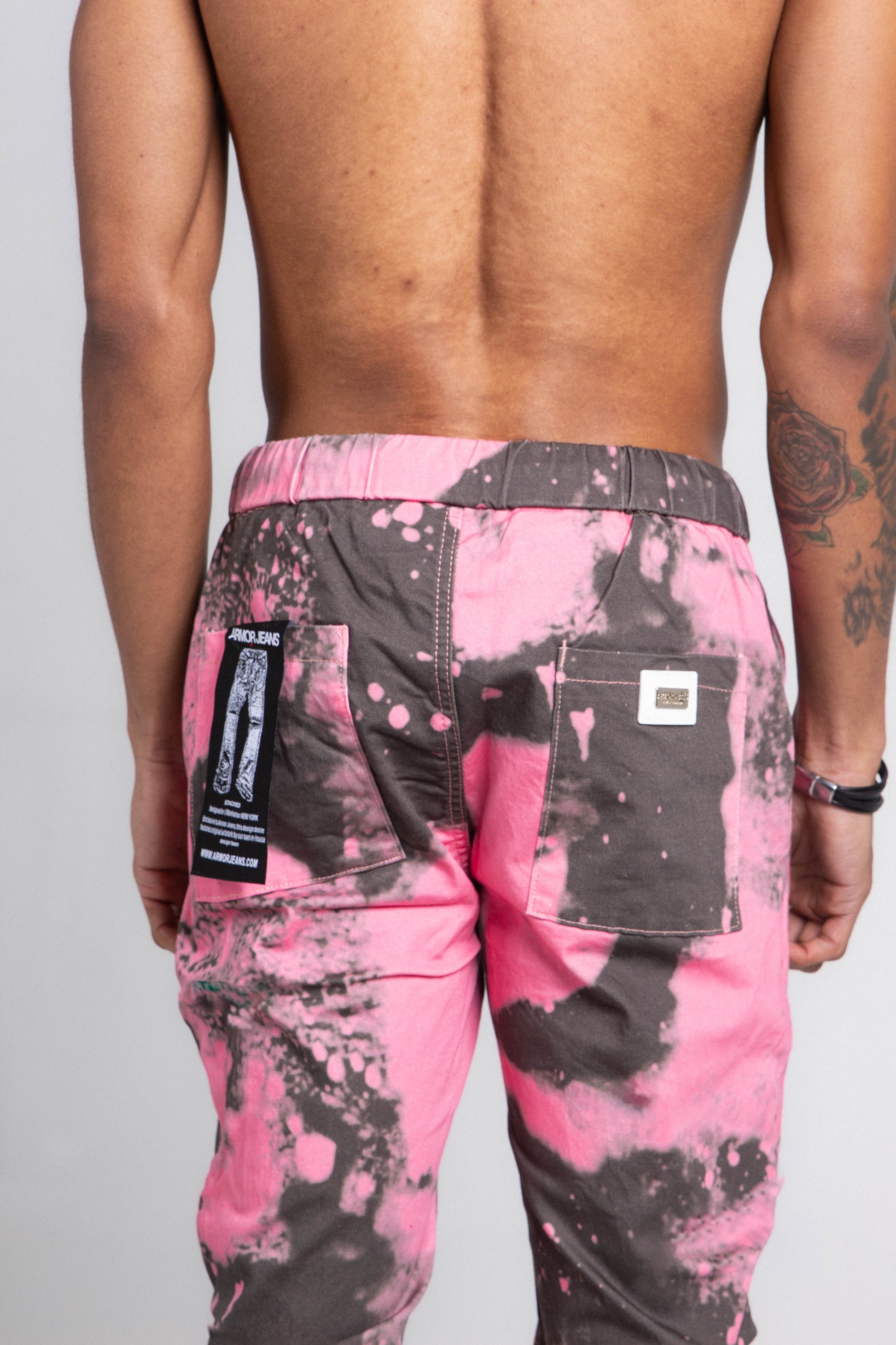 Back view of AJ04SK COLOR DYE STACKED JEANS in pink and orange with dye detail, mid-rise waist, elastic band, and five-pocket design.