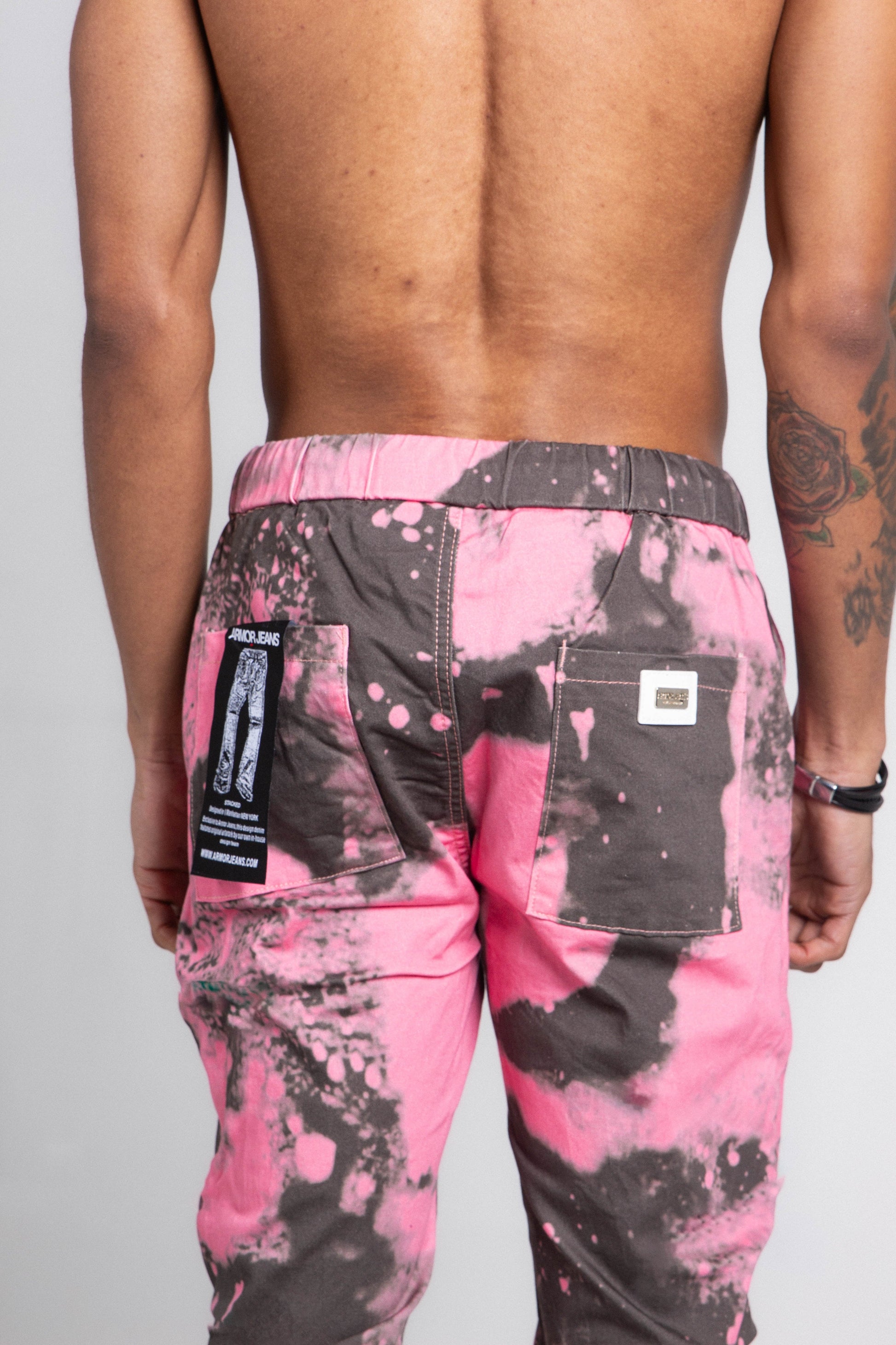 Back view of AJ04L COLOR DYE LOOSE JEANS with mid-rise waist, pink color dye detail, and elastic band fastening.