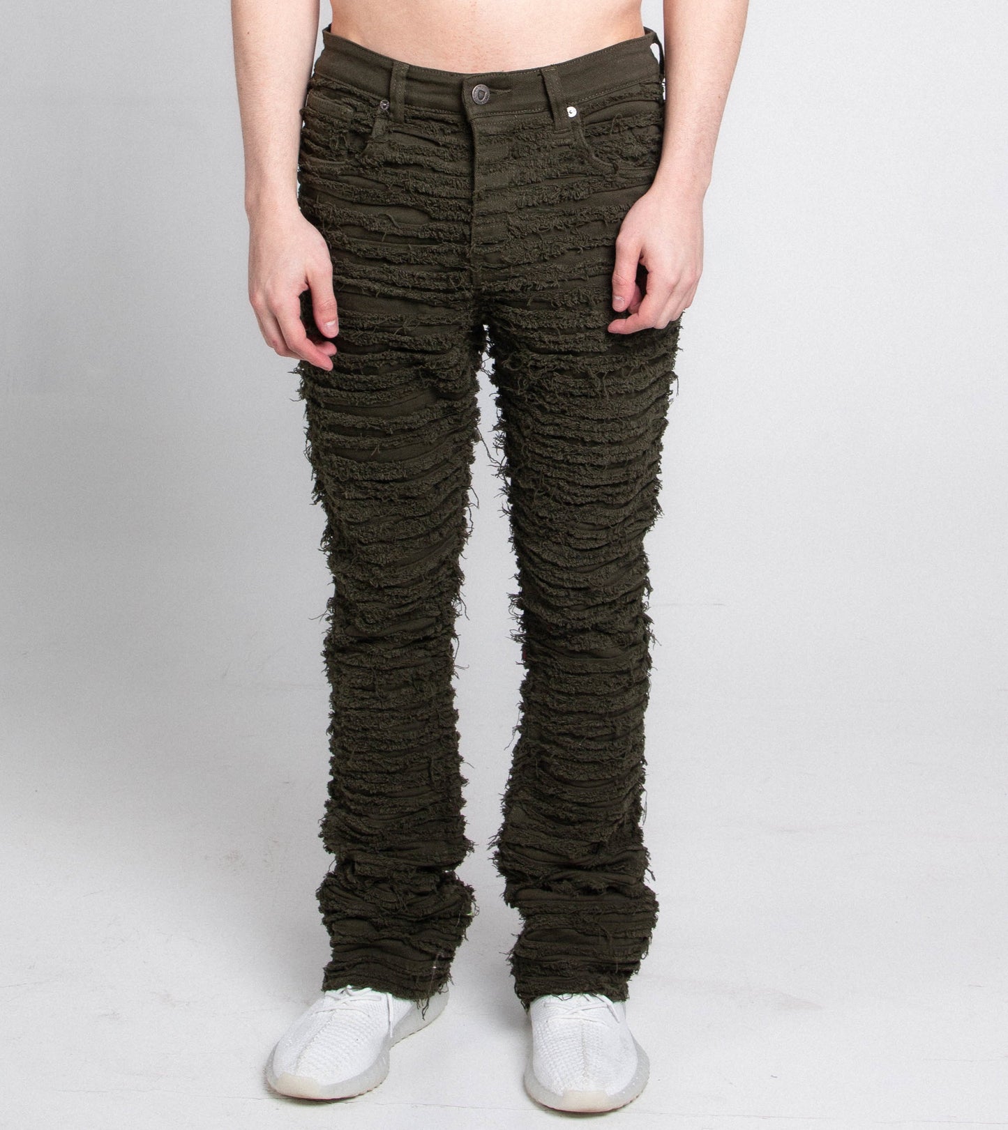 AJS693 EXTREME FRAYED STACKED JEANS with mid-rise, stretchy fabric, and a five-pocket design, worn by model standing.