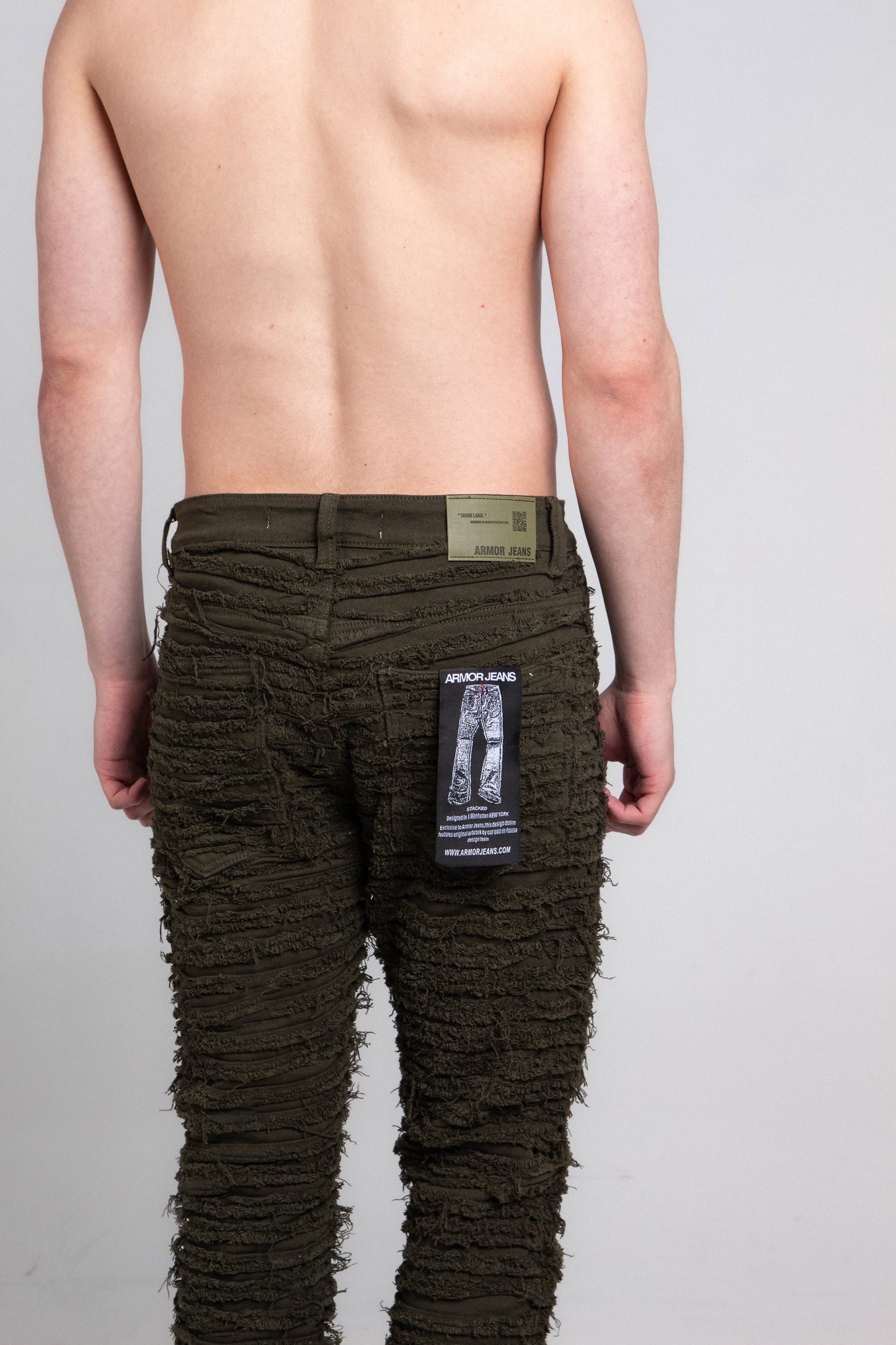 Back view of AJS693 EXTREME FRAYED STACKED JEANS showcasing frayed design and logo tag on a male model, mid-rise, stretchy fabric.
