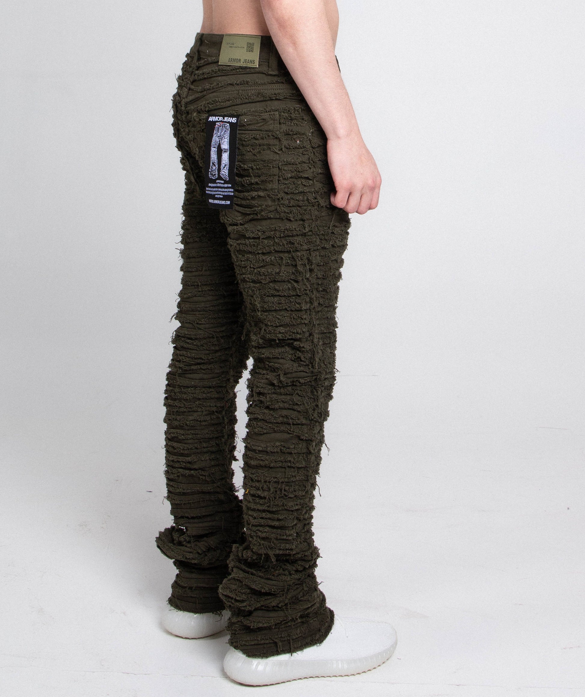 Model wearing AJS693 EXTREME FRAYED STACKED JEANS with mid-rise waist and five-pocket design in olive green.