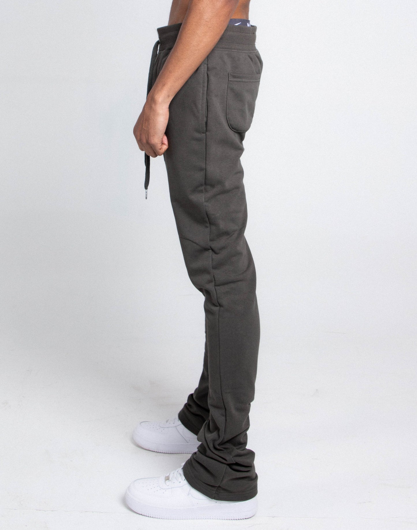 Side view of model wearing M5690-AJSKP MULTI-COLOR STACKED SWEATPANTS with elastic waistband, drawstrings, and pockets.