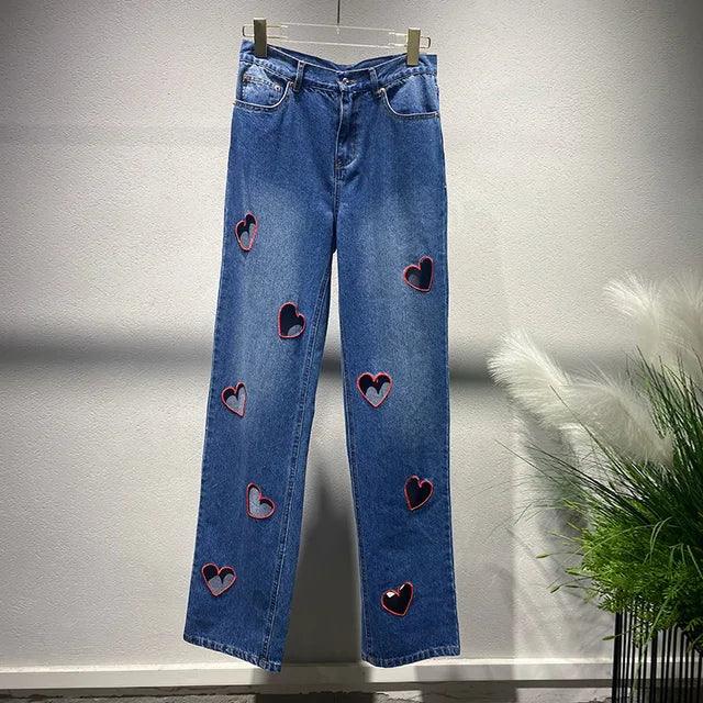 Heart Cutout Wide Leg Jeans | Romantic Wear for Women with heart-shaped cutouts embroidered on denim, hanging against a white background.