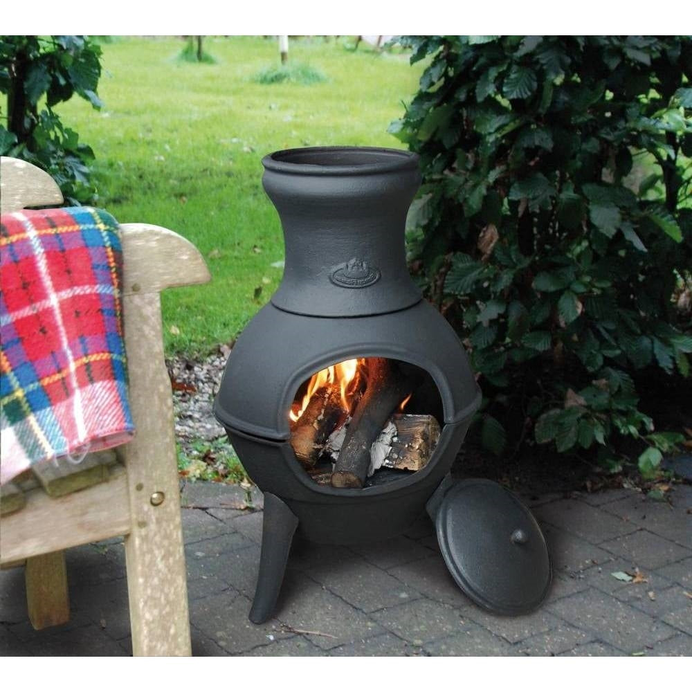 Small Black Outdoor Cast Iron Chimenea Wood Burning Fire Pit in a garden setting