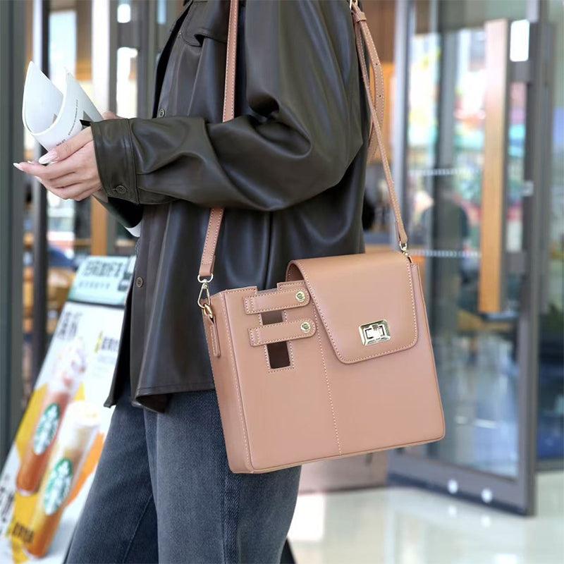 Person wearing brown leather jacket holding VersaStyle Crossbody Handbags in a stylish setting