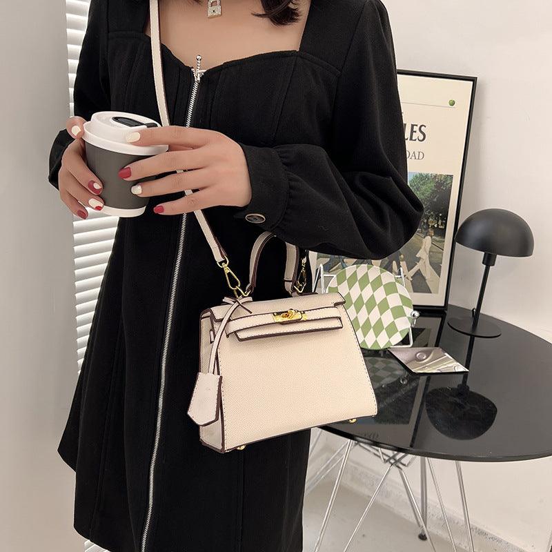 Woman holding the Luxury Cowgirl Kelly Purse – Trendy, High-Fashion Leather Handbag with Adjustable Strap, wearing a stylish black dress.