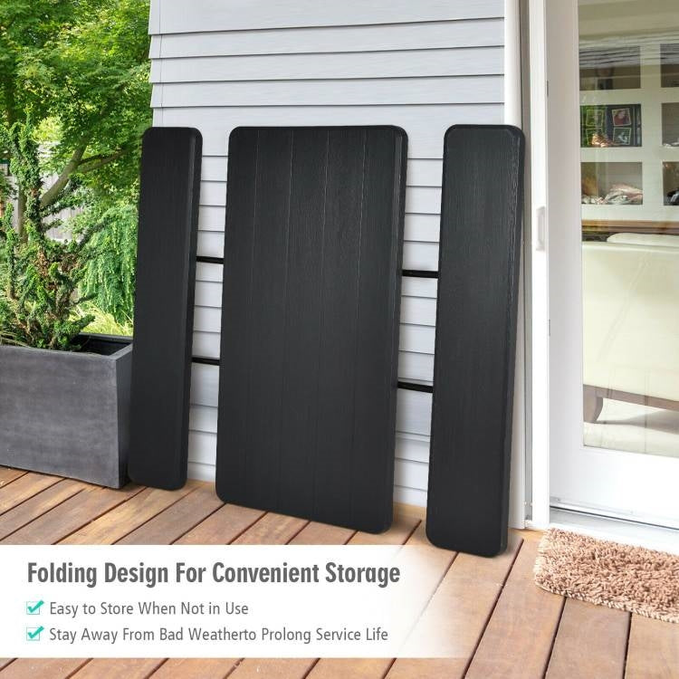 Folding Picnic Table with 2 Benches Outdoor Patio Dining Set in Black stored against wall on patio
