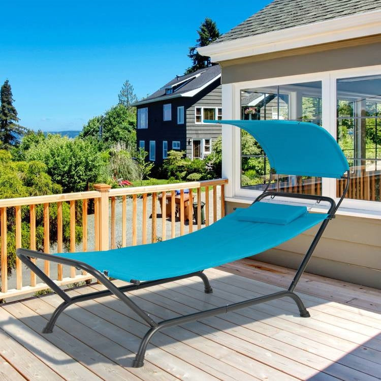 Blue Polyester Chaise Lounge Chair Hammock with Canopy and Storage Bag on a sunny outdoor deck.