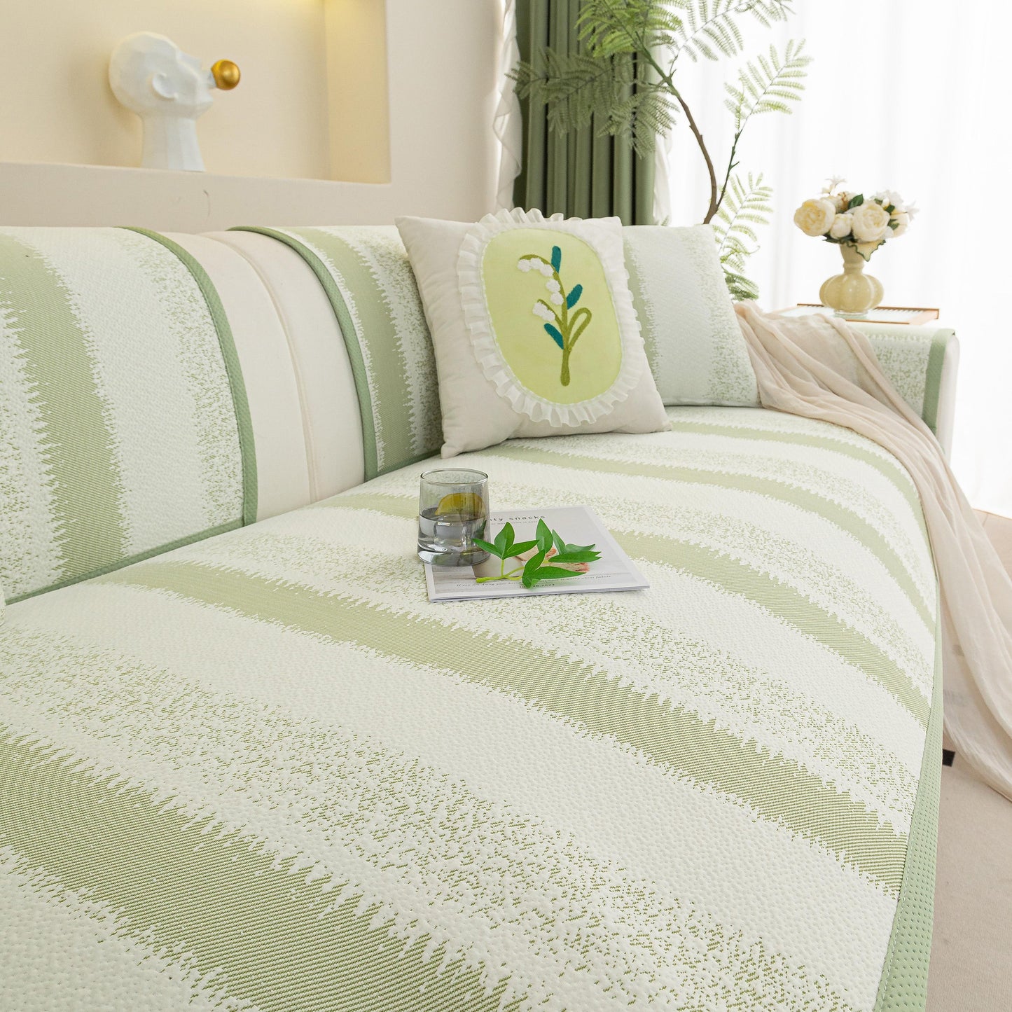 Living room with a green and white Striped Non-Slip Cooling Couch Cover, Summer Couch Pads for Seat Back Armrest on a modern sofa.